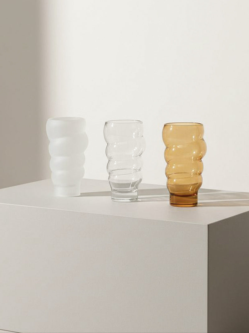 Set of three wavy ribbed glasses in white, clear and amber tones