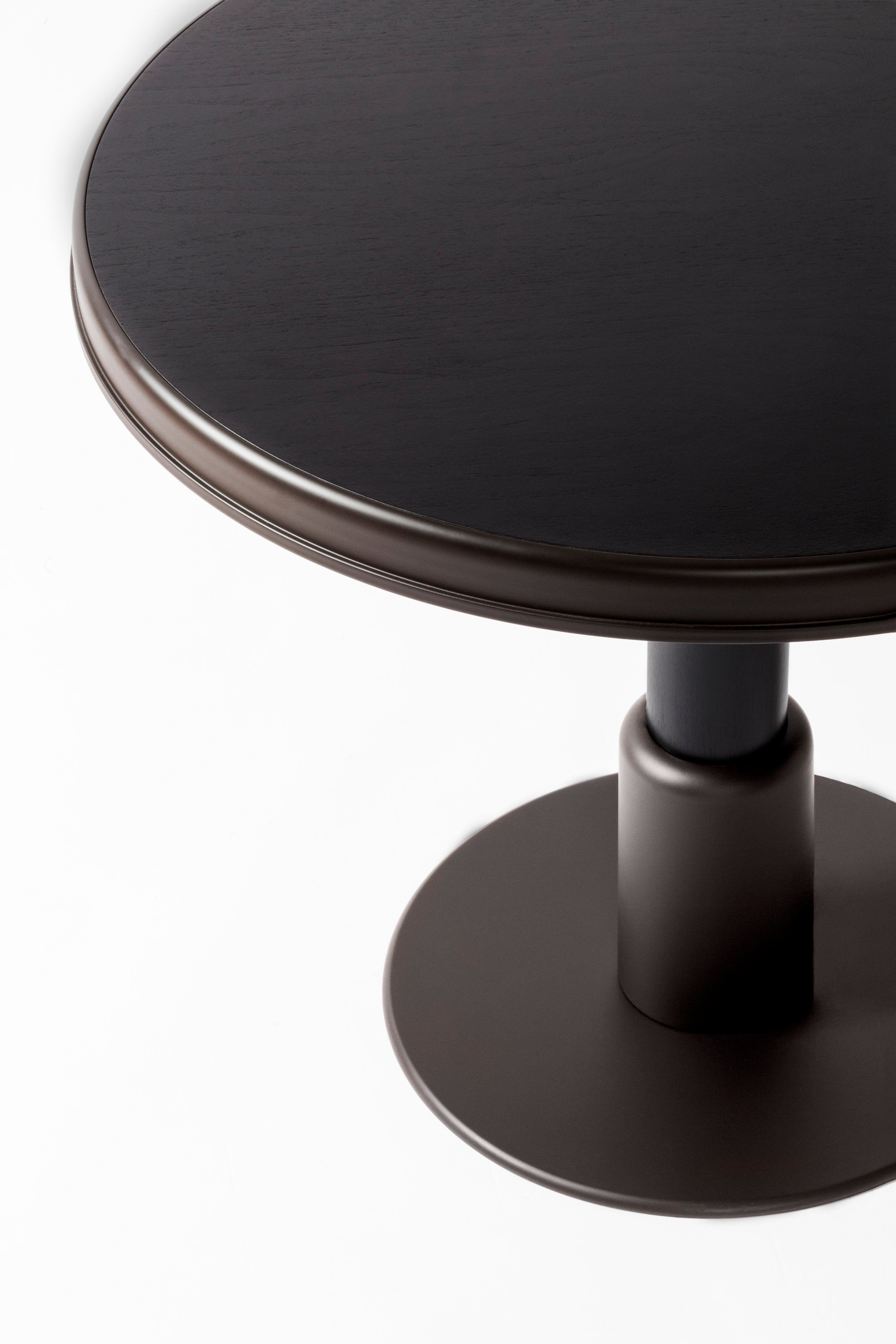Round dark wood dining table with pedestal base detail