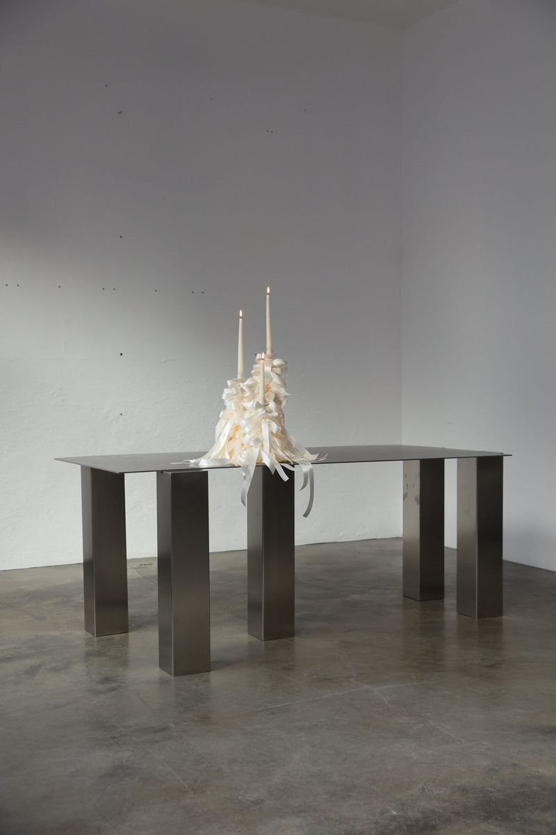 Atrium Desk — close-up of polished metal surface with candles