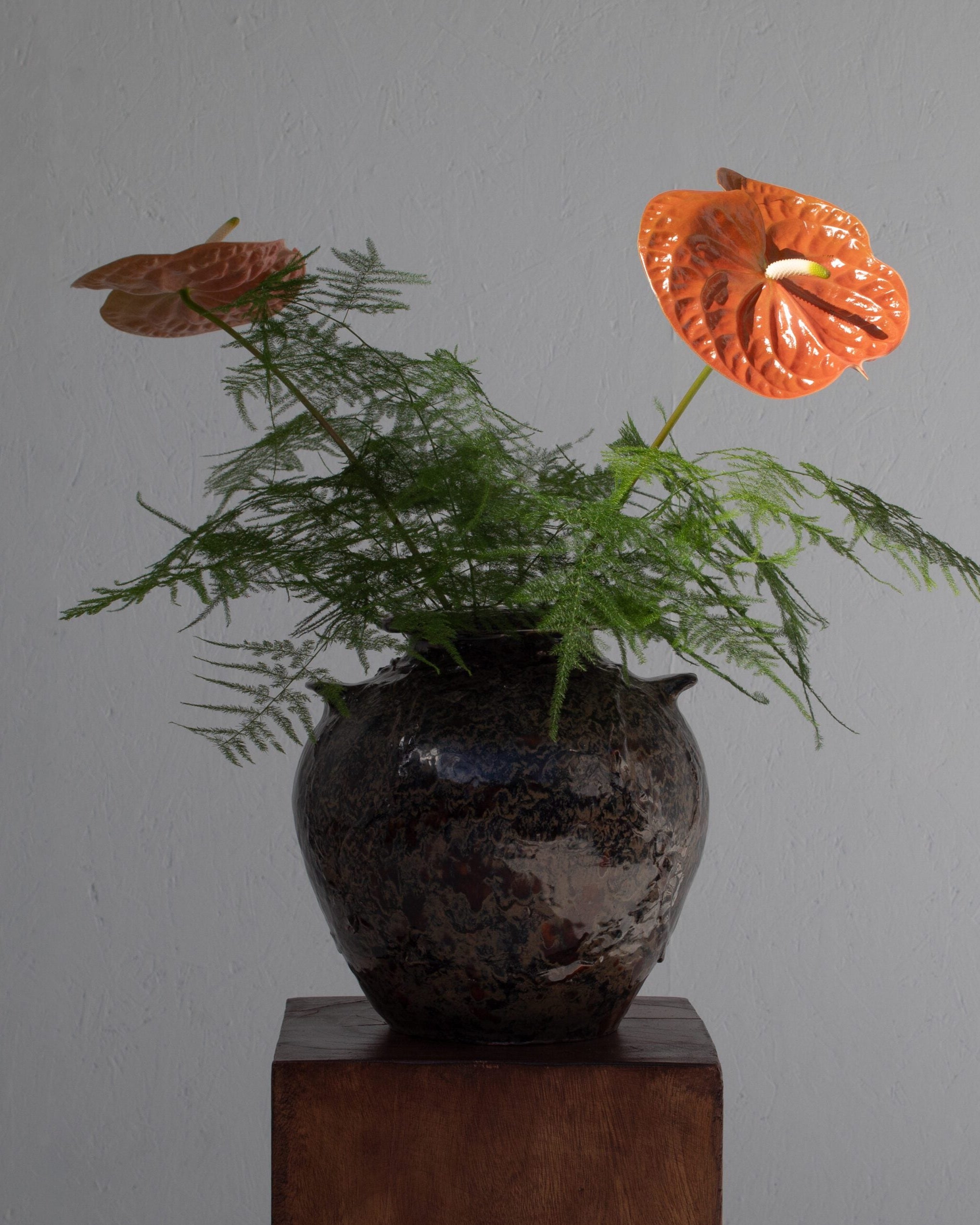 Ceramic Flower Pot / Vase — close-up of dark ceramic with orange flowers