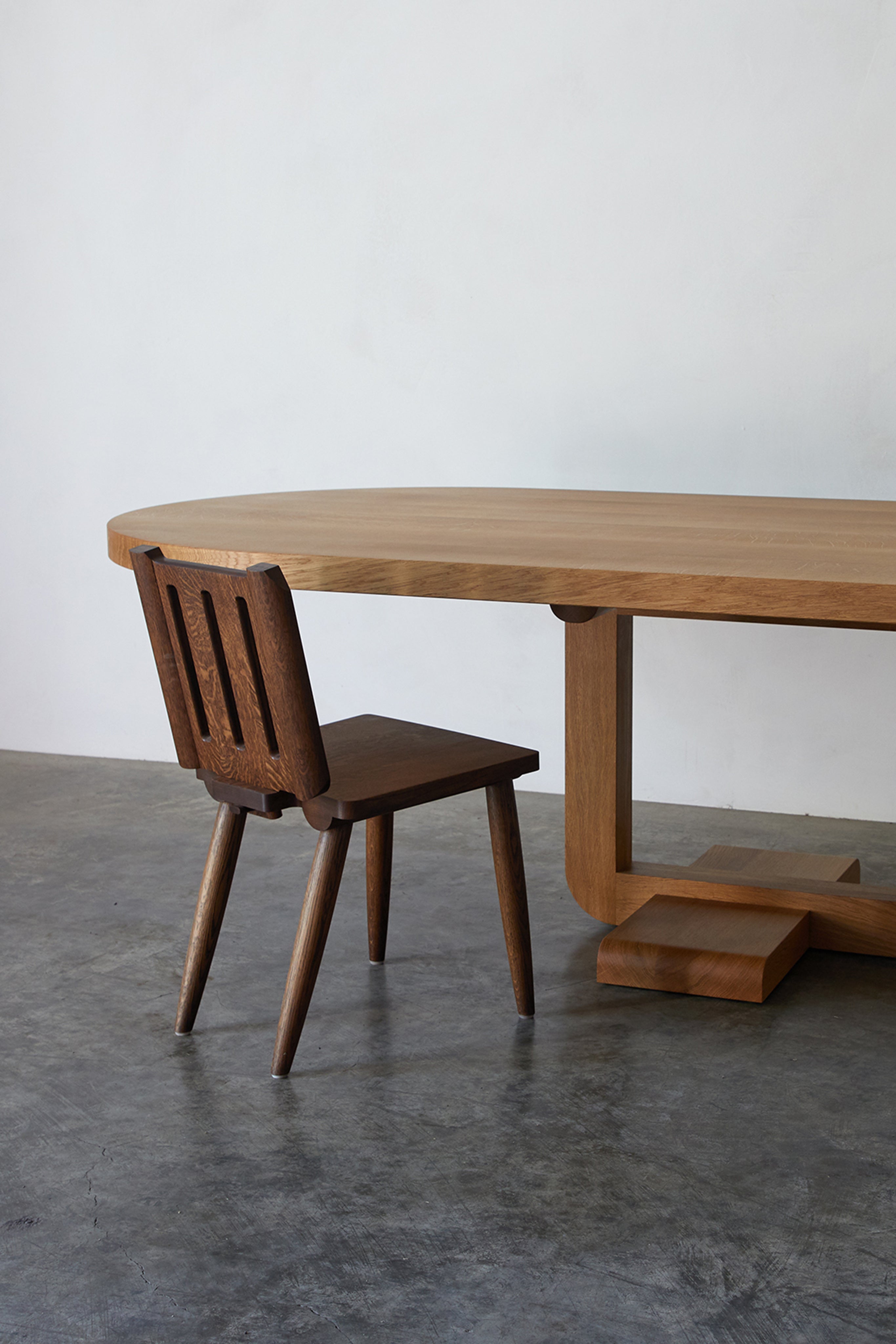 Alpine Chair — side angle with dark wood against light table