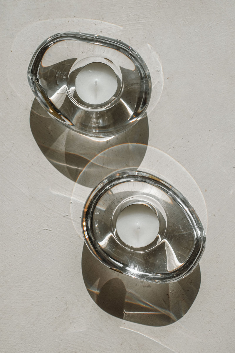 Crystal candleholders casting geometric shadows on marble surface