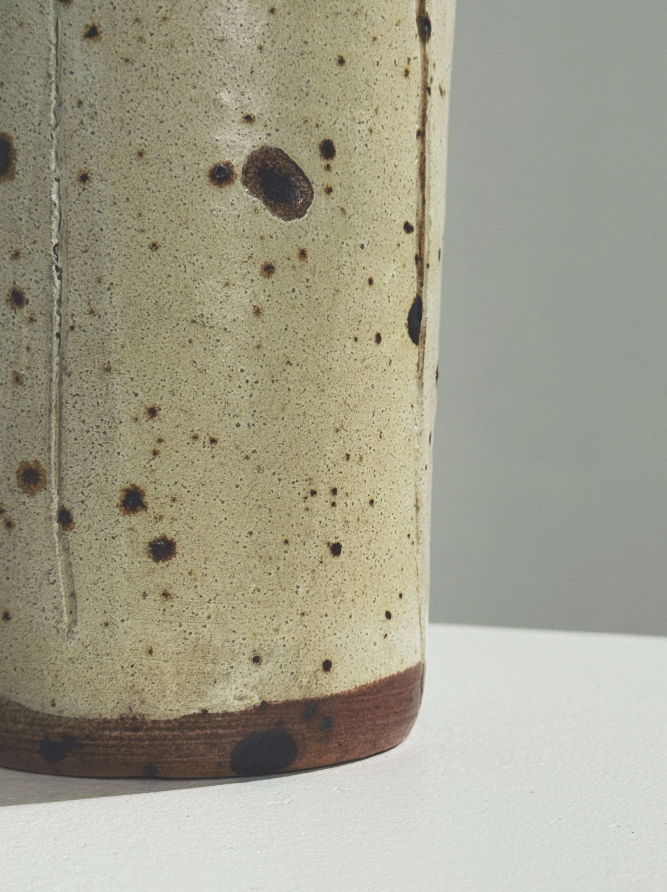 Close-up detail of speckled cream stoneware vase texture 1960s