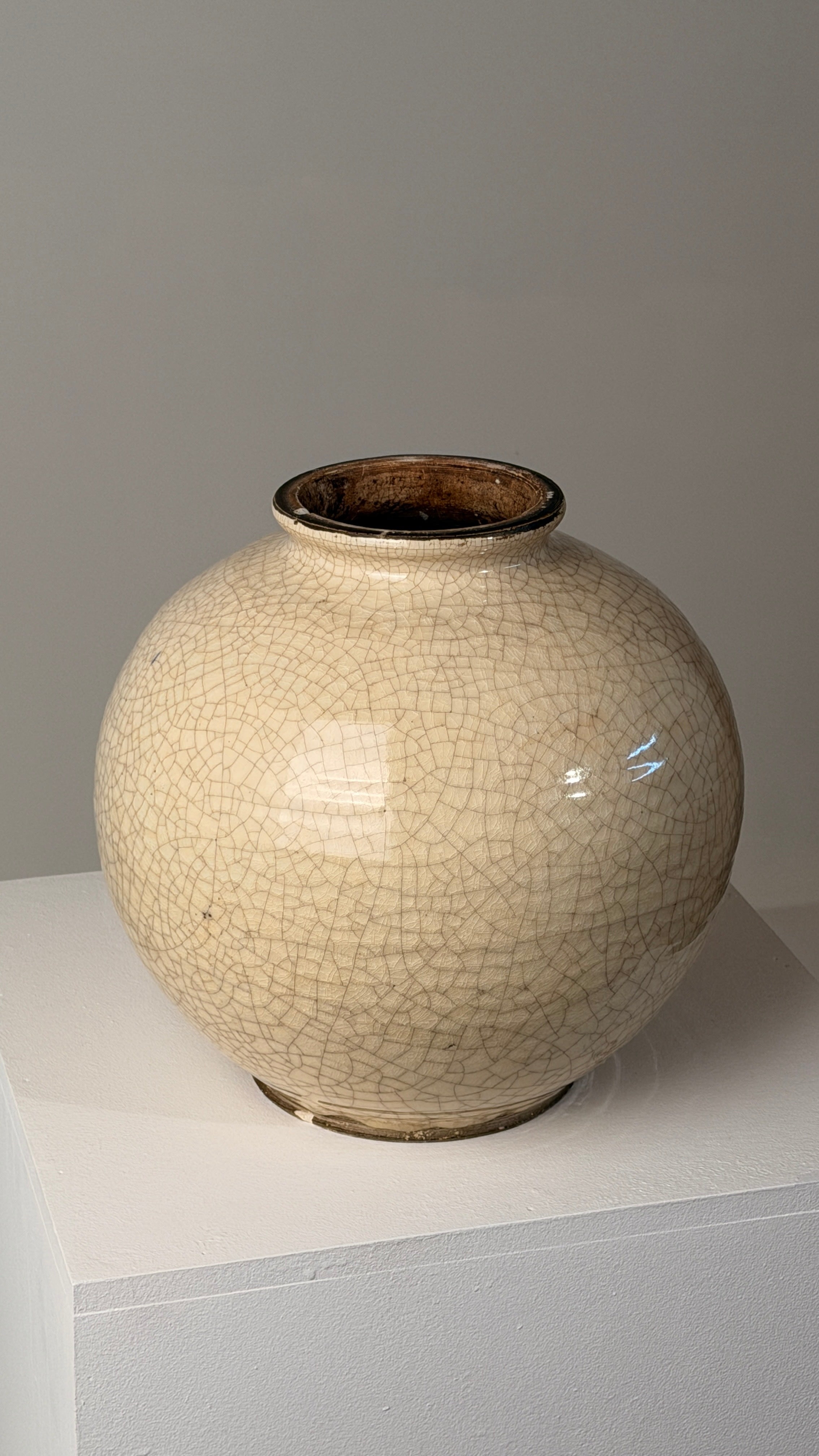Important crackled white ceramic vase, France, circa 1930, Art Deco period — side angle on white pedestal