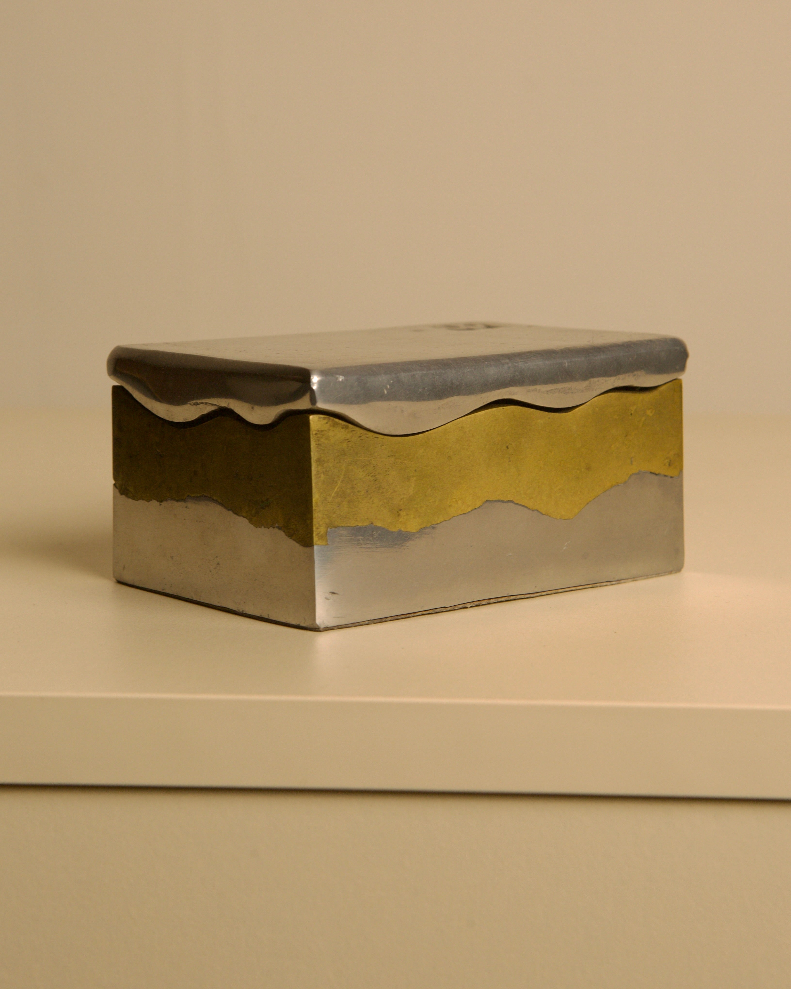 Brutalist metal and brass box by David Marshall, 1970s — angled view on neutral surface