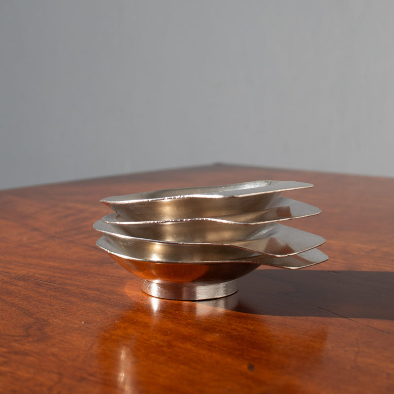 Arthur Krupp Dessert Plates in Metal — side view of stacked plates on wood table