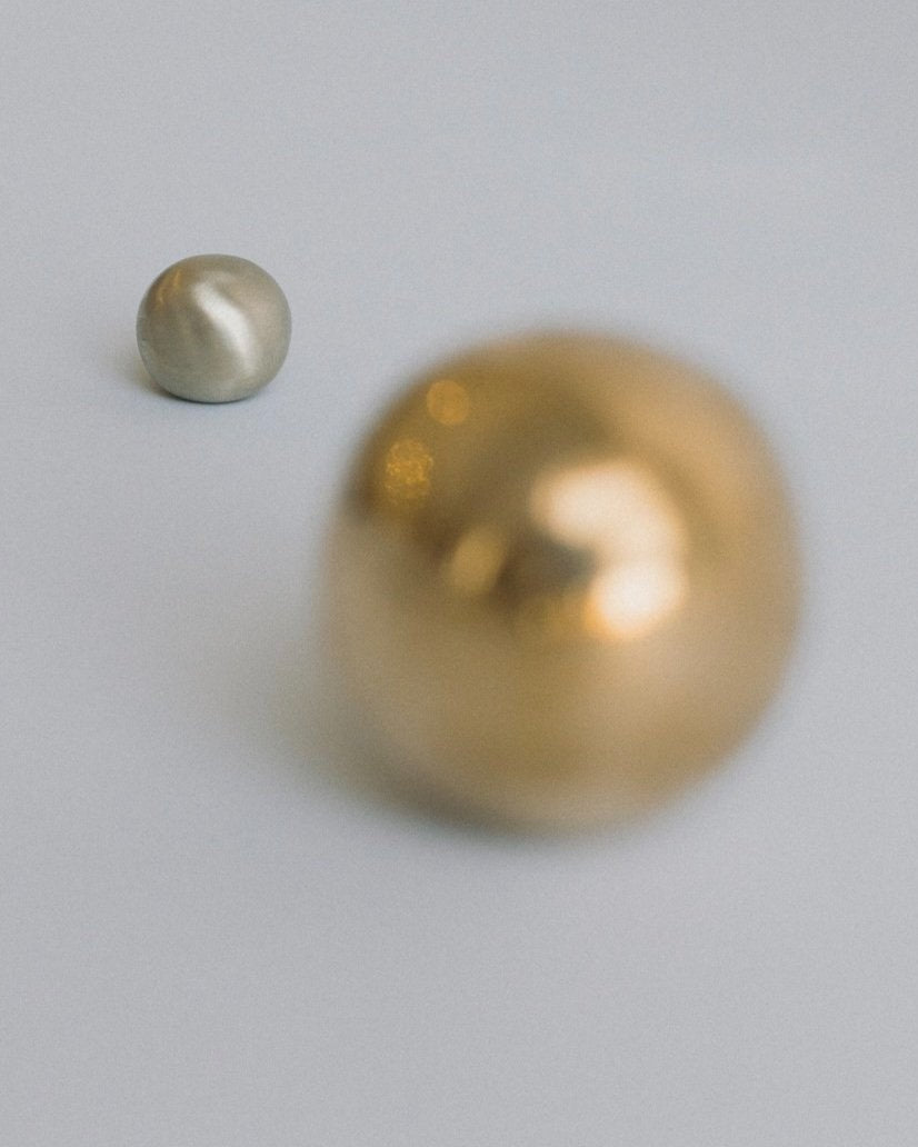 CERCLE Cabinet Knob Large — blurred view of brass knobs on gray surface