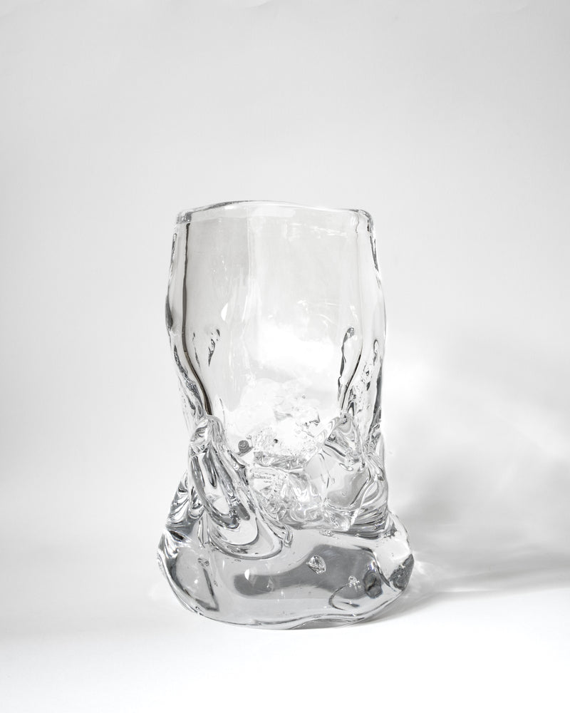 The Organically Shaped Hand-blown Vase No. 2 by Szkło Studio features a unique form and textured surface, set against a white background with a soft shadow—a stunning showcase of handcrafted glass artistry.