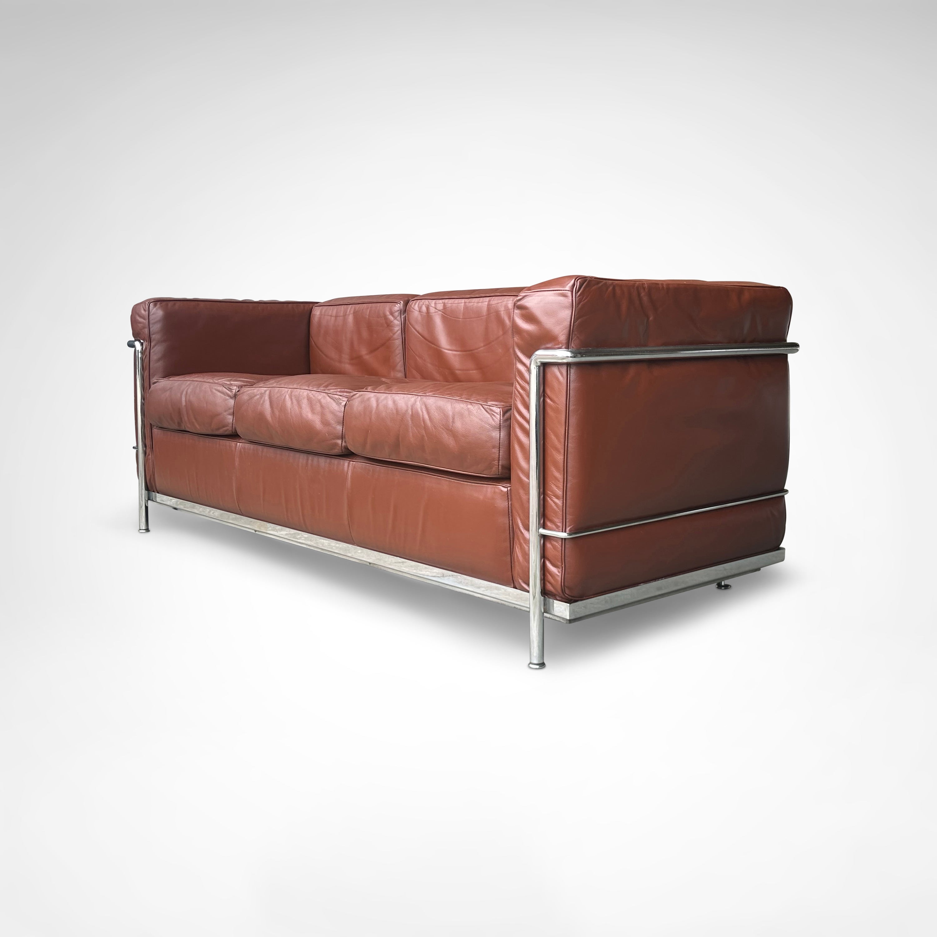 Early production LC2 leather 3-seater sofa by Le Corbusier et al Cassina 1970s — angled view highlighting rich brown leather