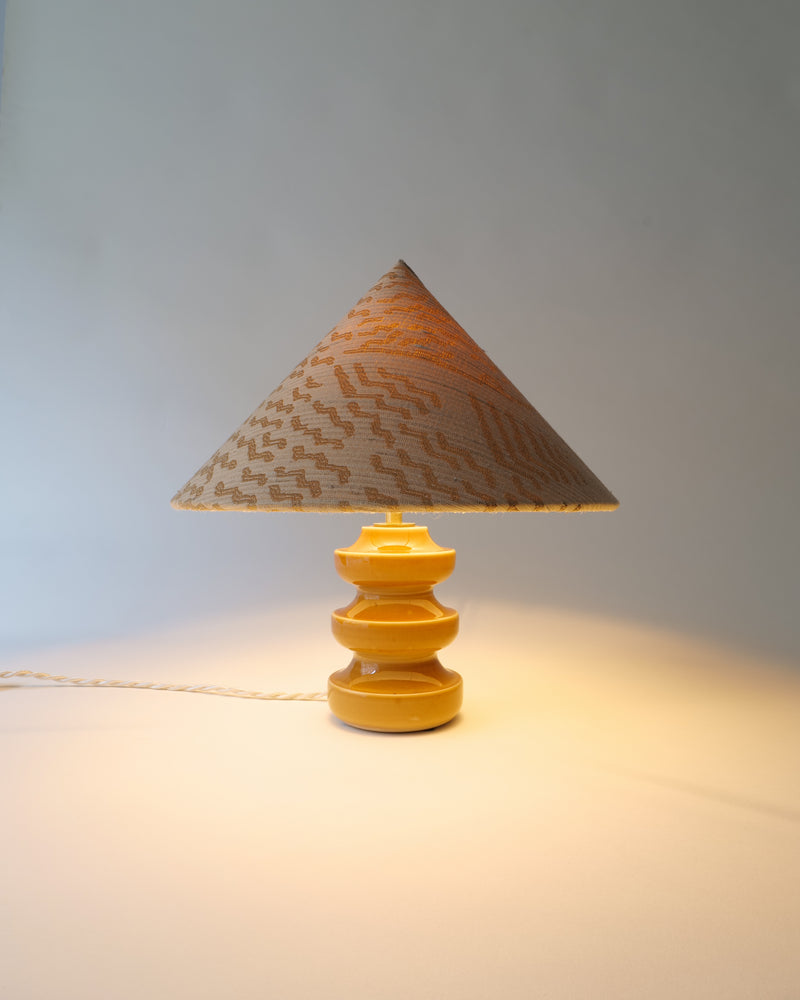 Sculptural table lamp with conical woven shade and tiered wood base