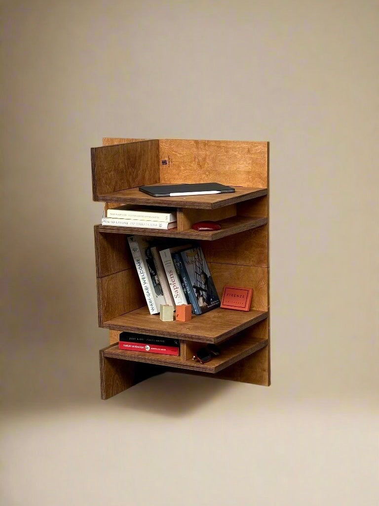 The "Sisto" Versatile Wood Chair by Edoardo Lietti Studio stands in a corner, its geometric form serving as sculptural furniture while offering storage for books, a red notepad, and a tablet against a beige background.