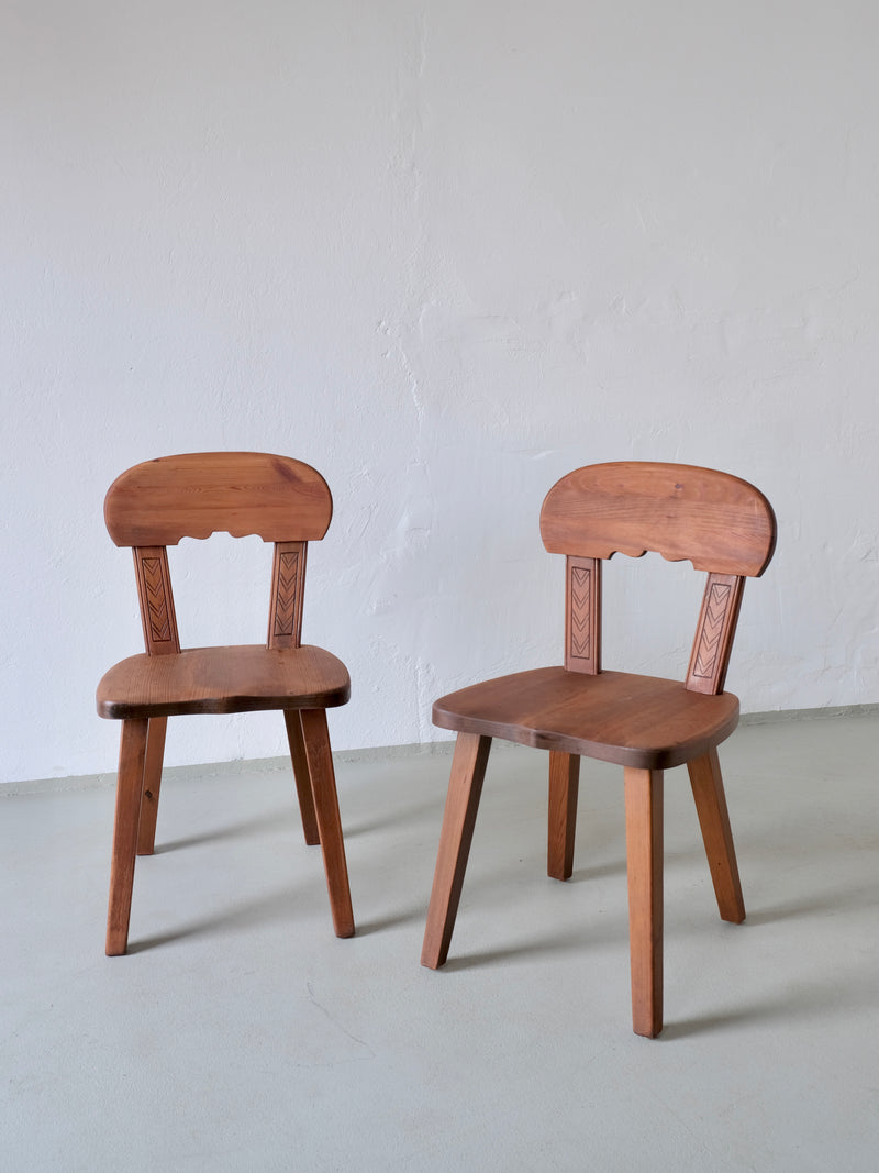 Pair of carved pine chairs with decorative backrest details, Sweden 1940s