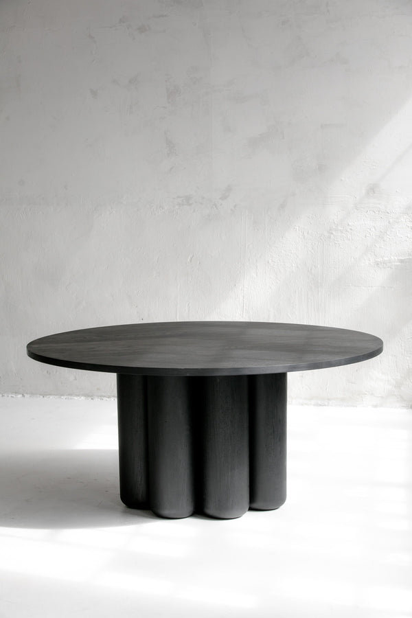Ina Dining Table in Solid Wood — round black table in minimalist setting