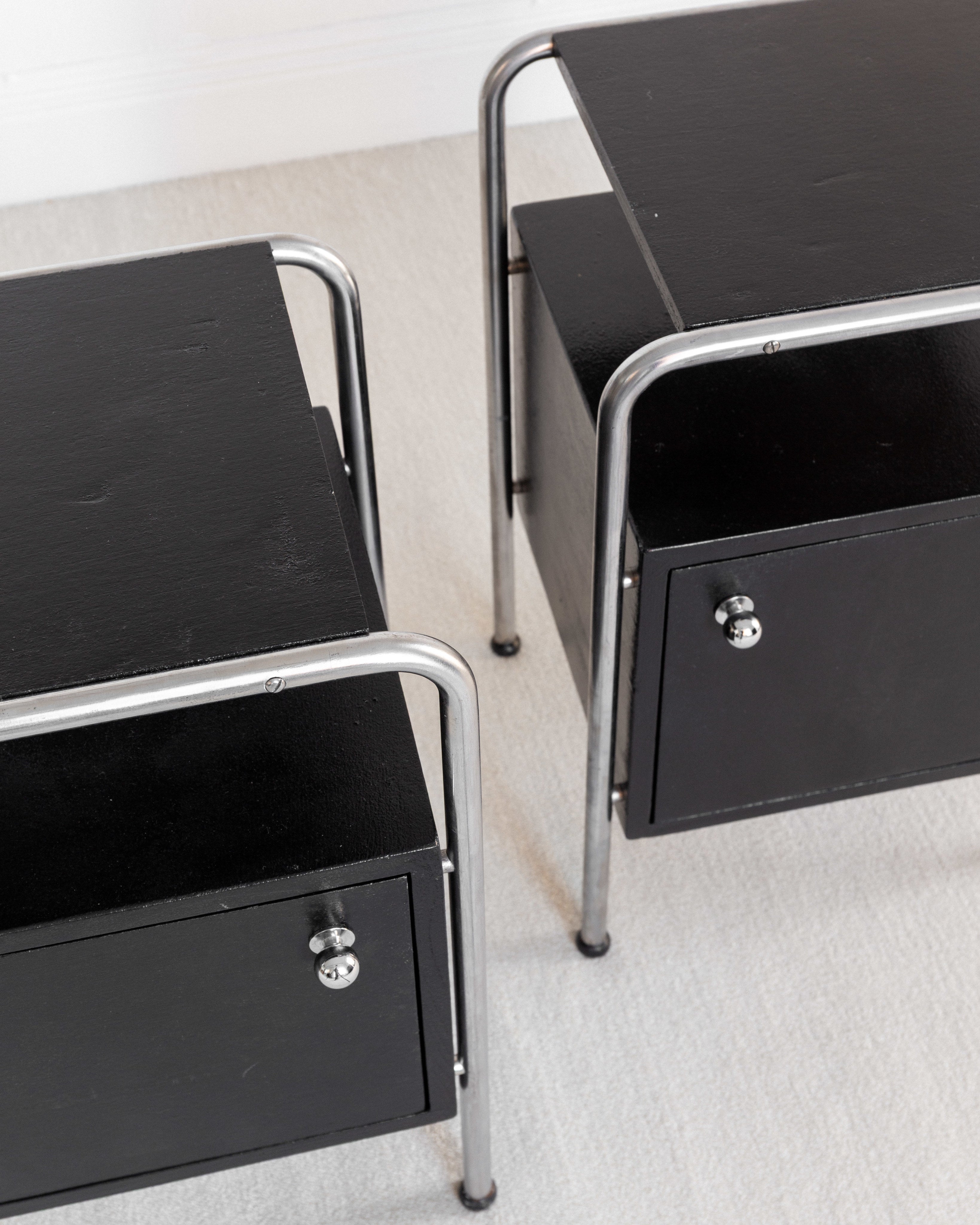 Pair of Functionalist Nightstands, Sweden 1930s — close-up of black surface and metal legs