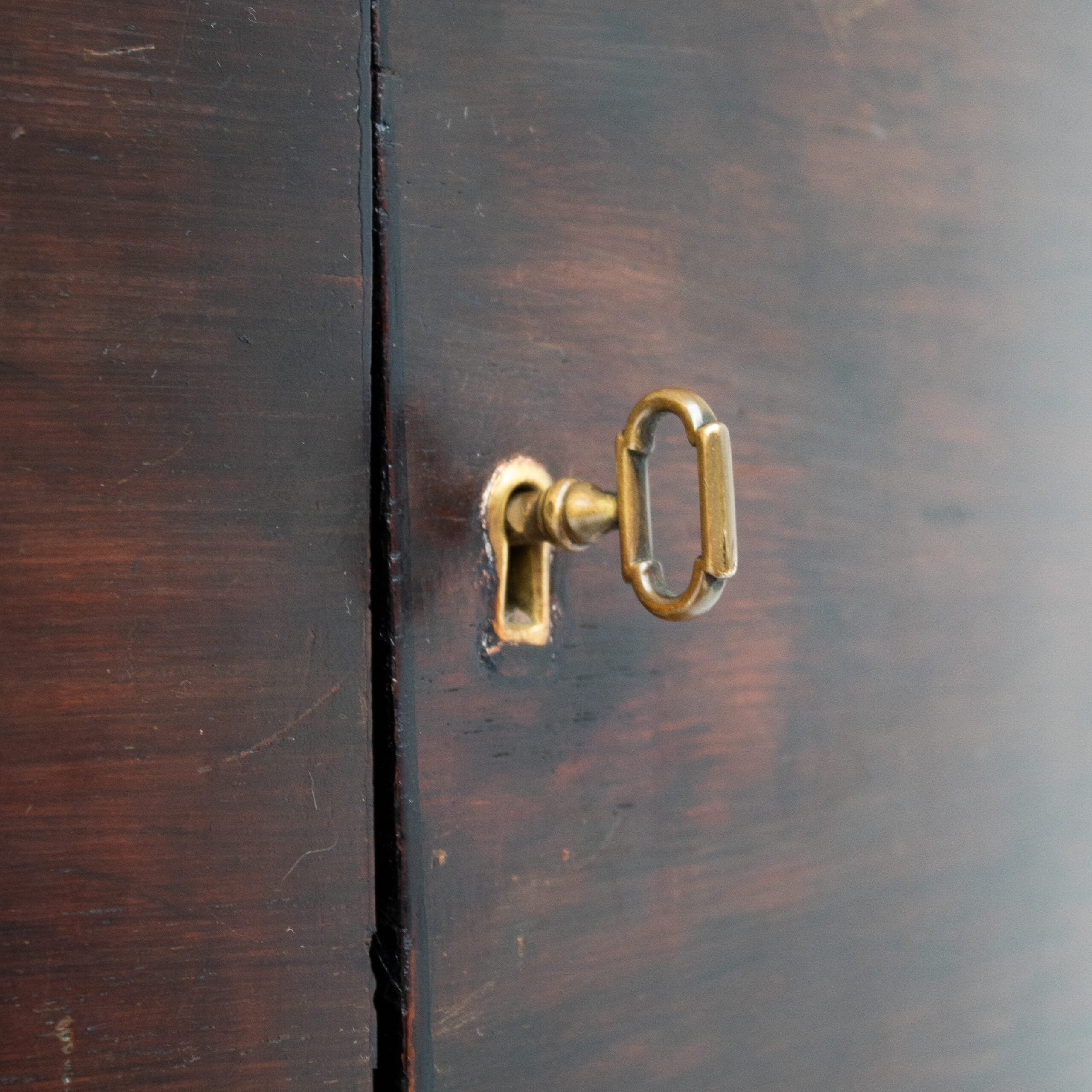 Art Deco Cabinets — close-up of brass keyhole on dark wood