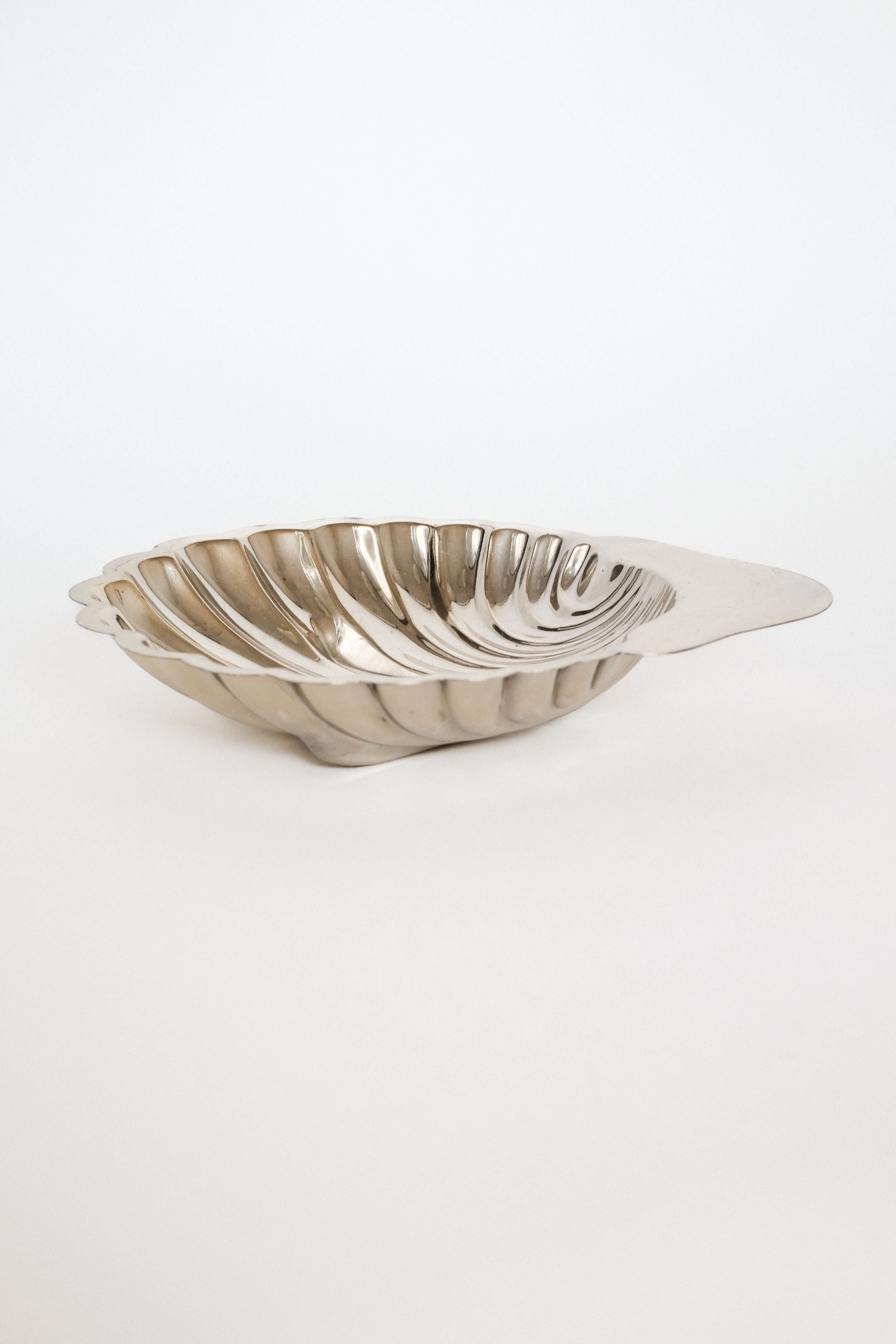 Medium Shell Shaped Vide-poches — angled view of polished metal dish
