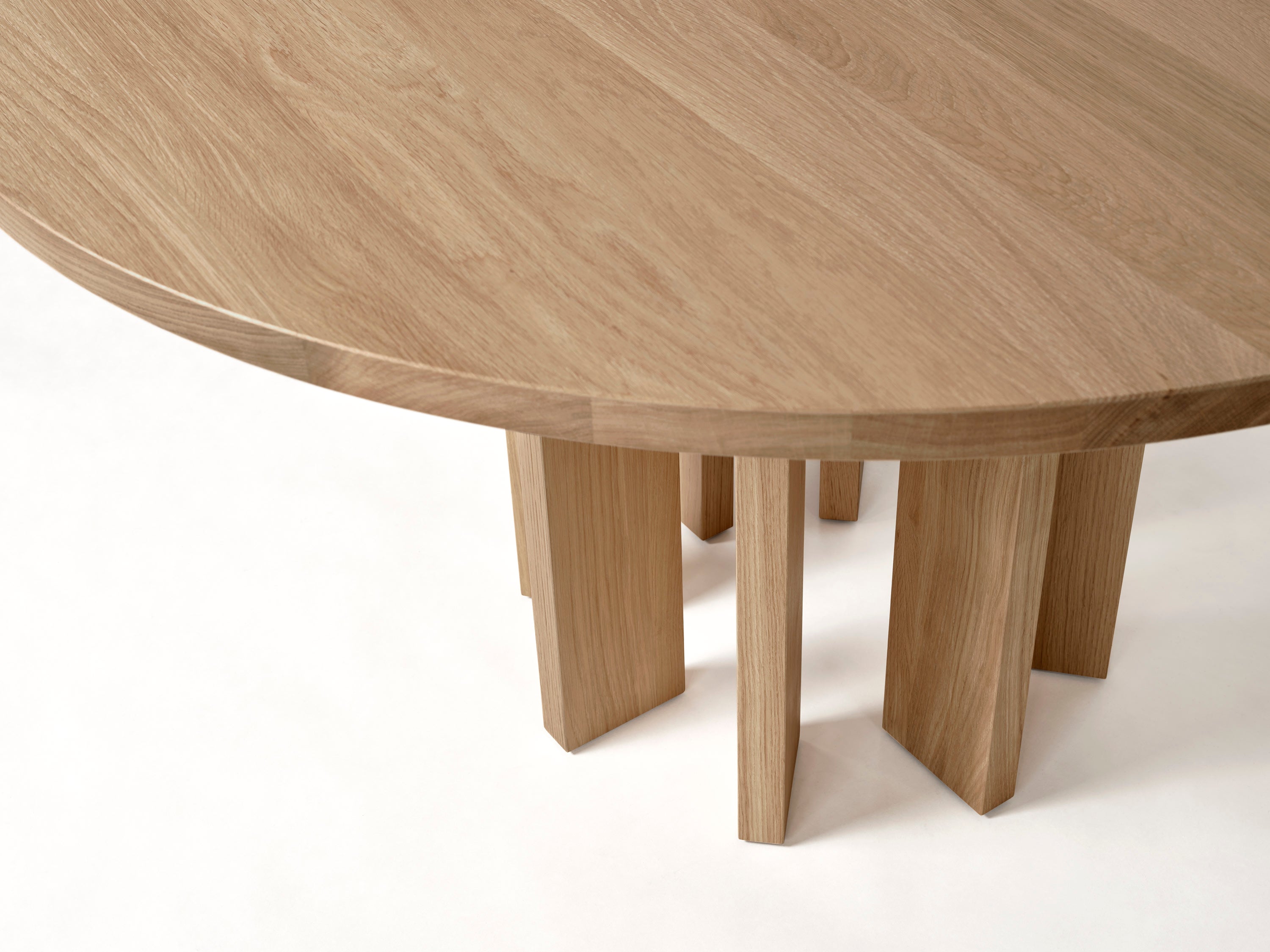 Thola Round Table — close-up of light oak surface and legs