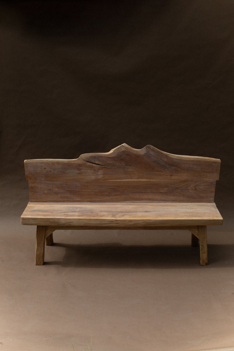Brutalist wooden bench with carved mountain backrest detail
