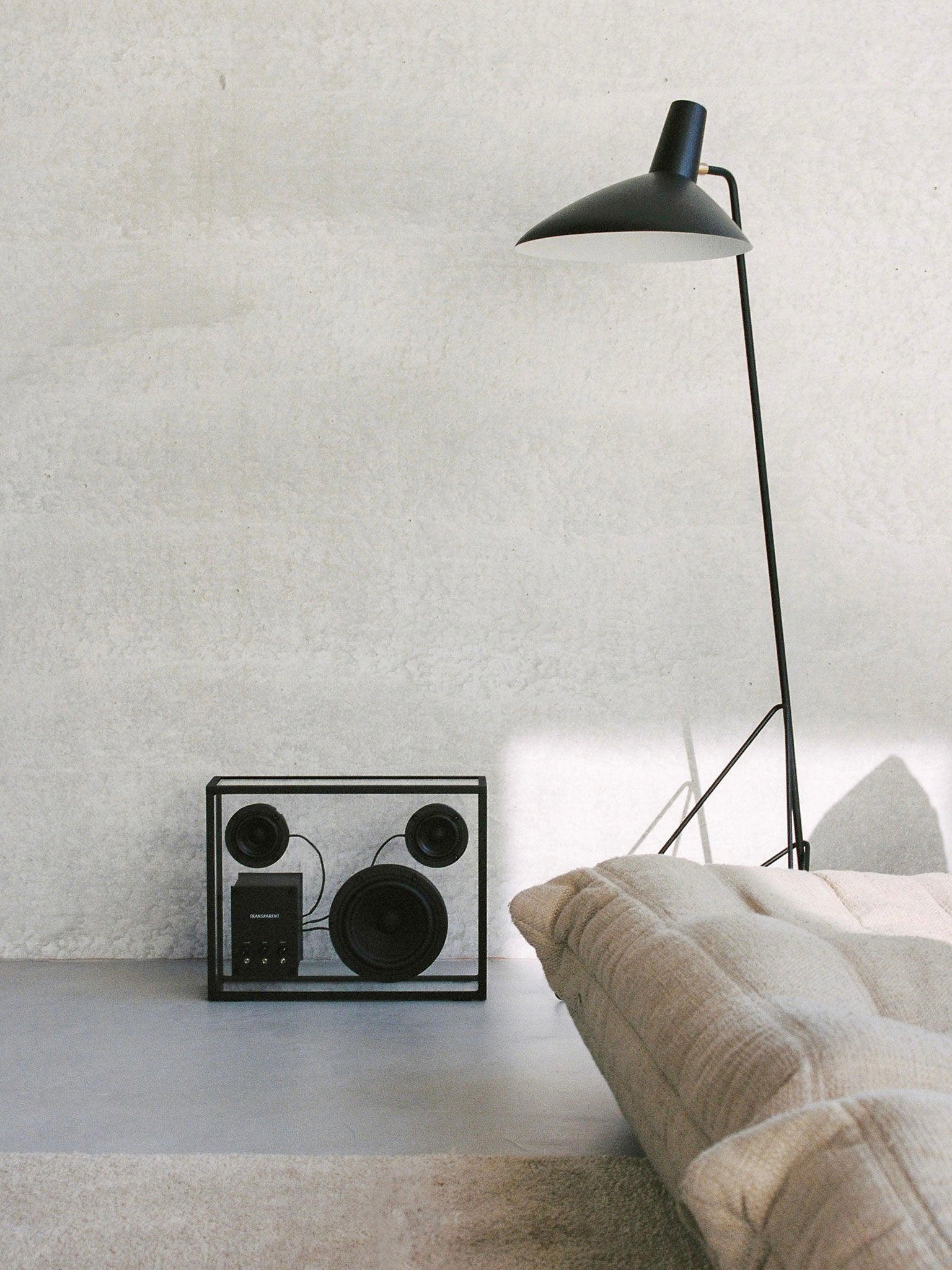 Transparent Speaker Black - Bluetooth — side view on minimalist gray surface