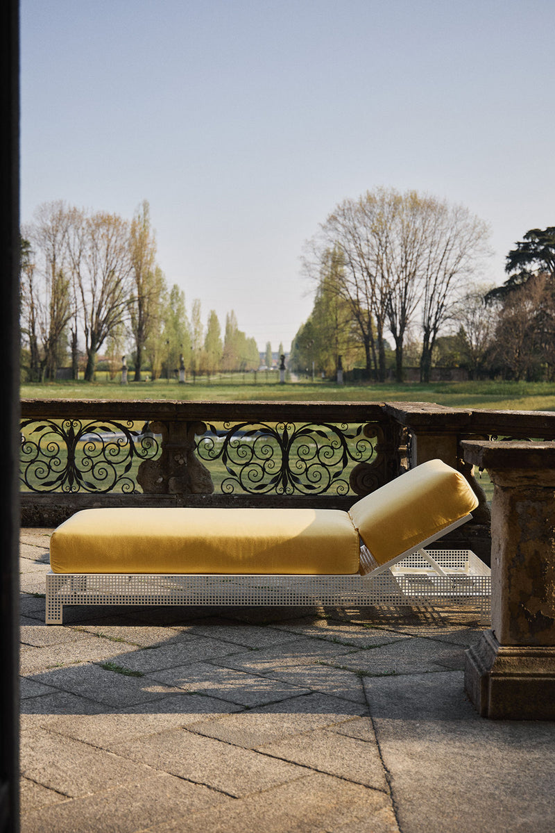 Conservatory' Sun Lounger — angled view on patio with yellow cushion