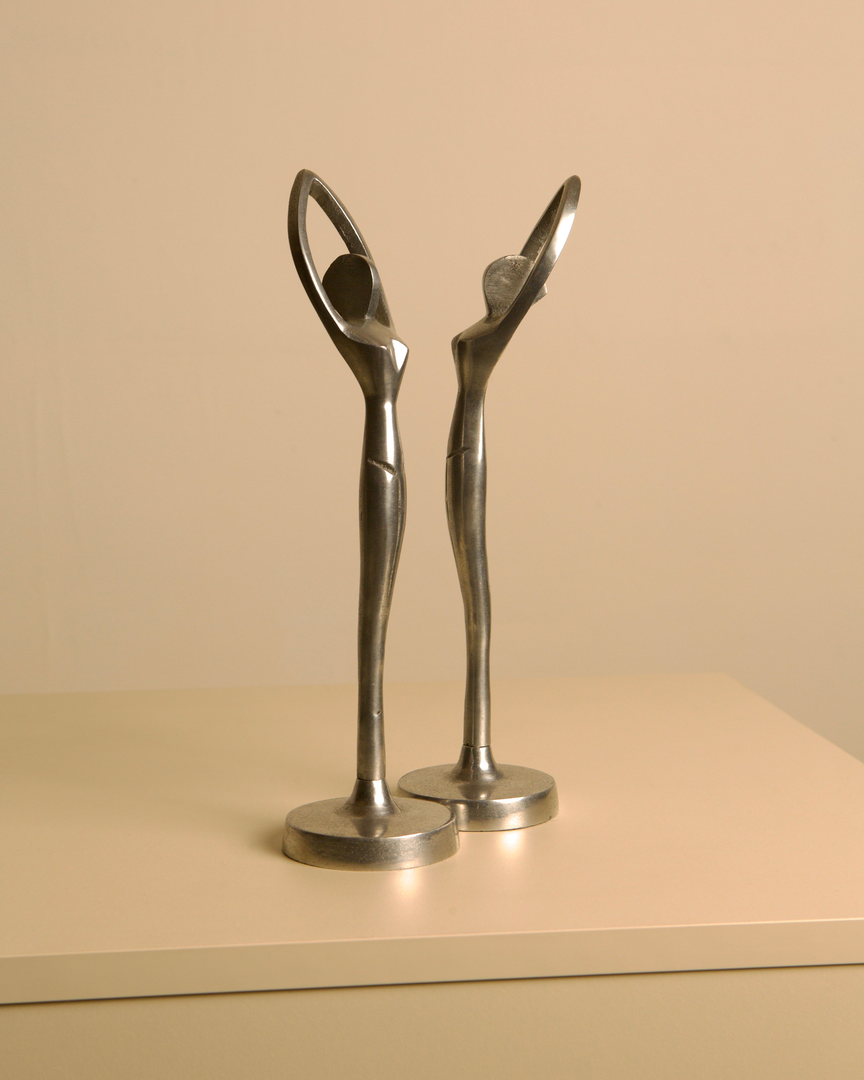 Pair of Italian aluminum dancers from the 80s — side angle on neutral background