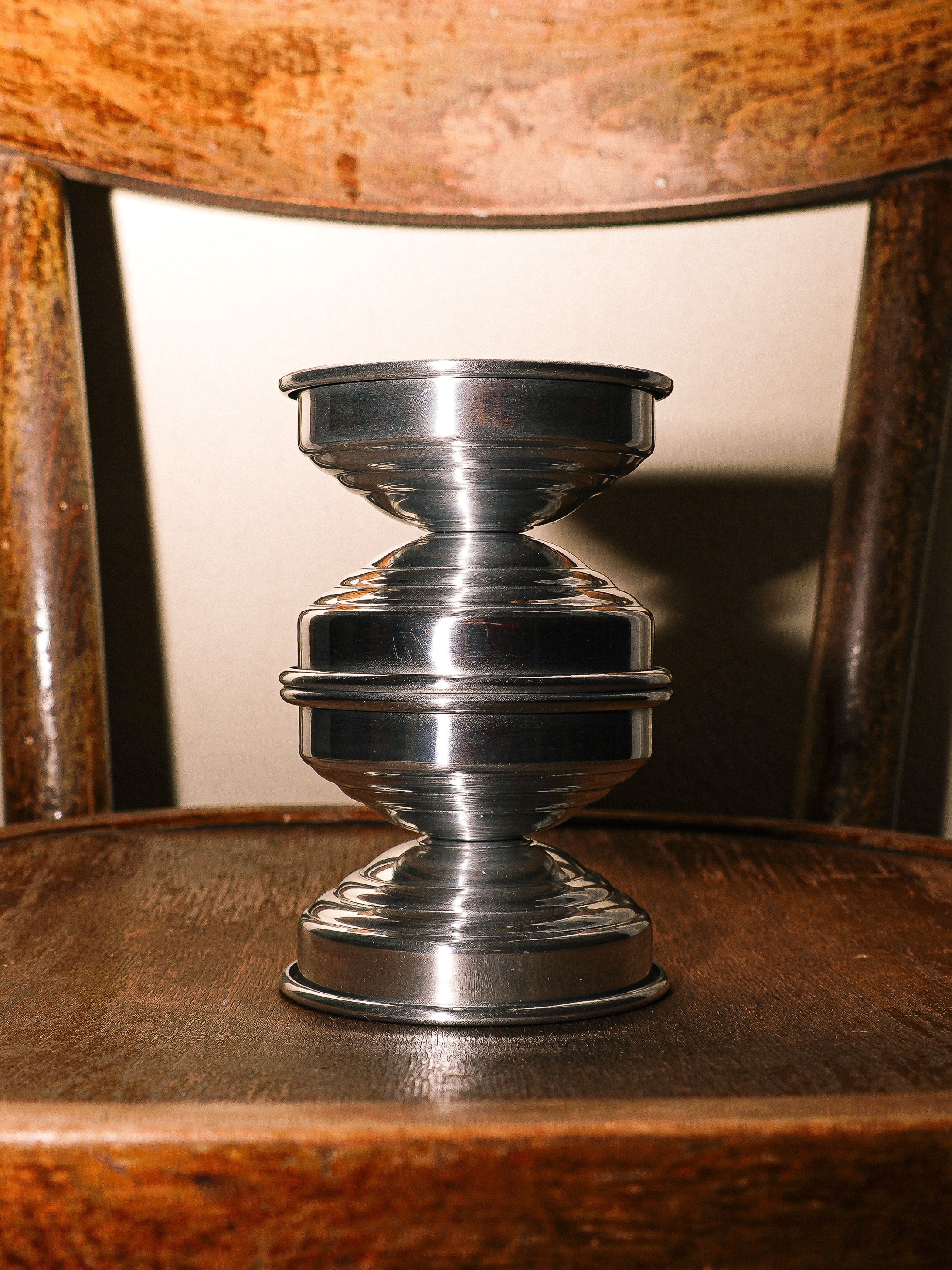 Metal Candle Holders in Polished Aluminum — close-up on wooden chair