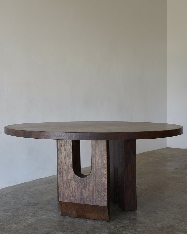 Tulia Round Dining Table — close-up of dark wood surface and base