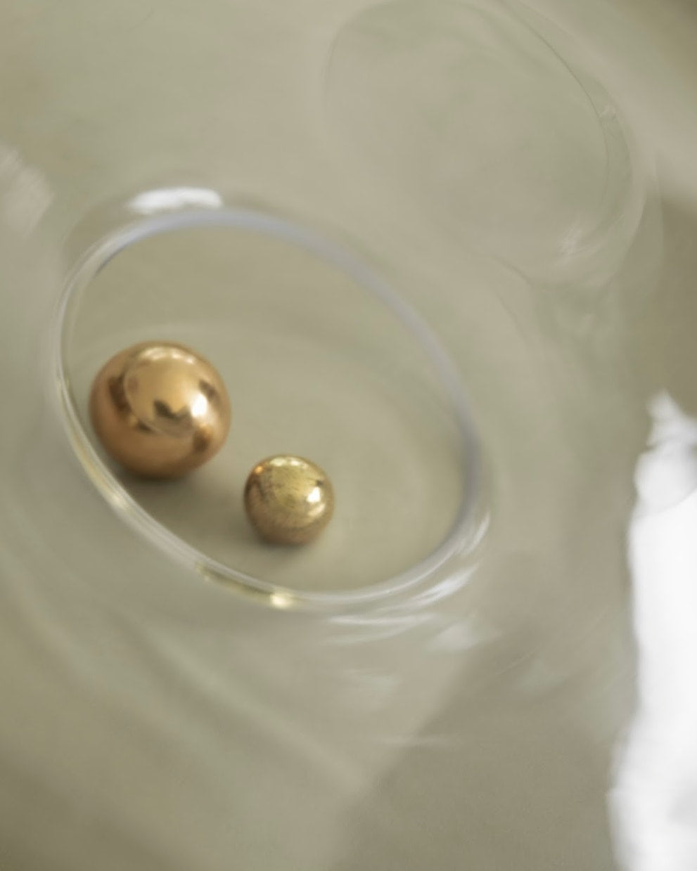 CERCLE Cabinet Knob Large — close-up of brass knobs on glass surface