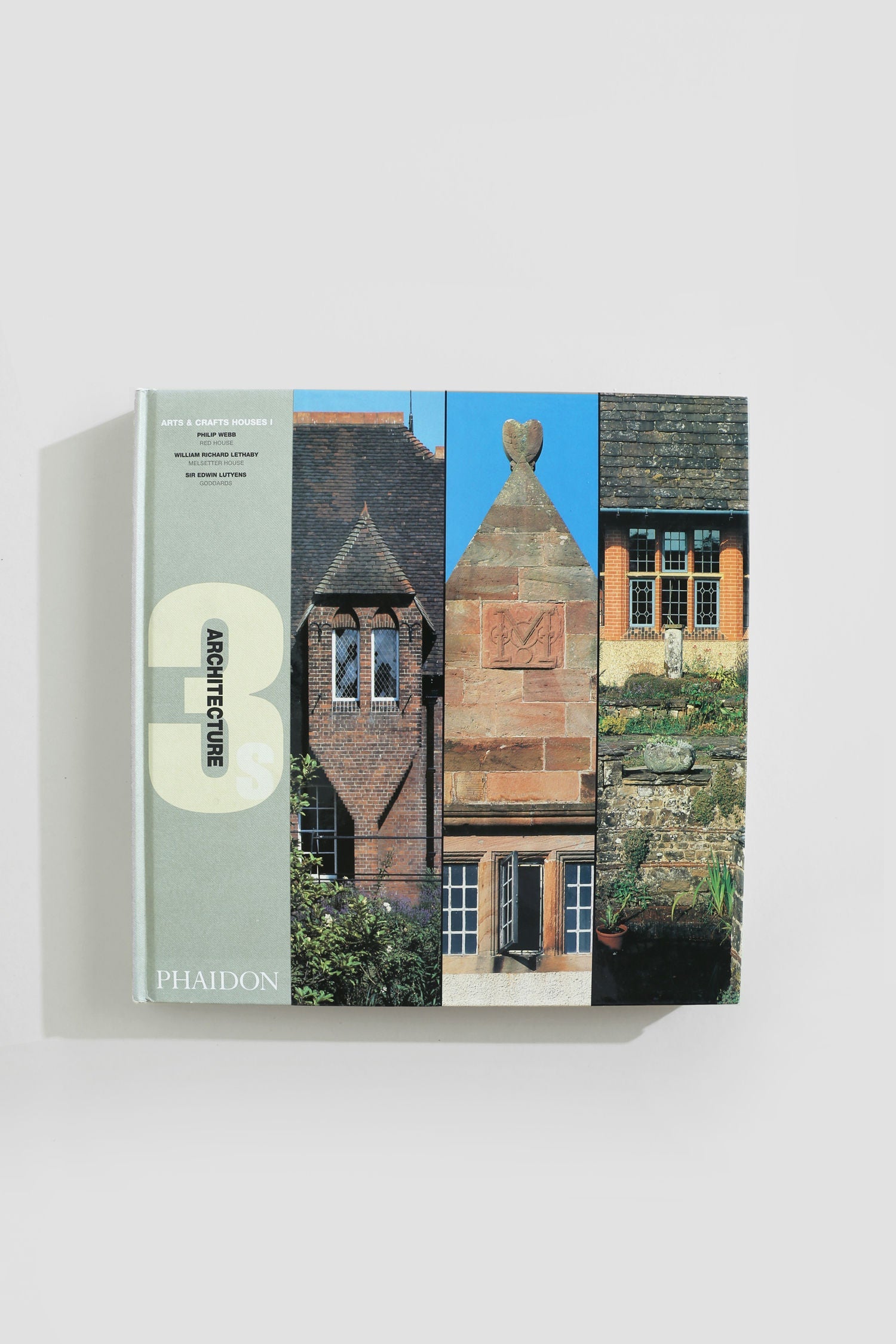 A hardcover "Architecture Book Series - Set of 5" by Villa lies on a white surface, its cover displaying three vertical panels with unique architectural details from historic buildings.