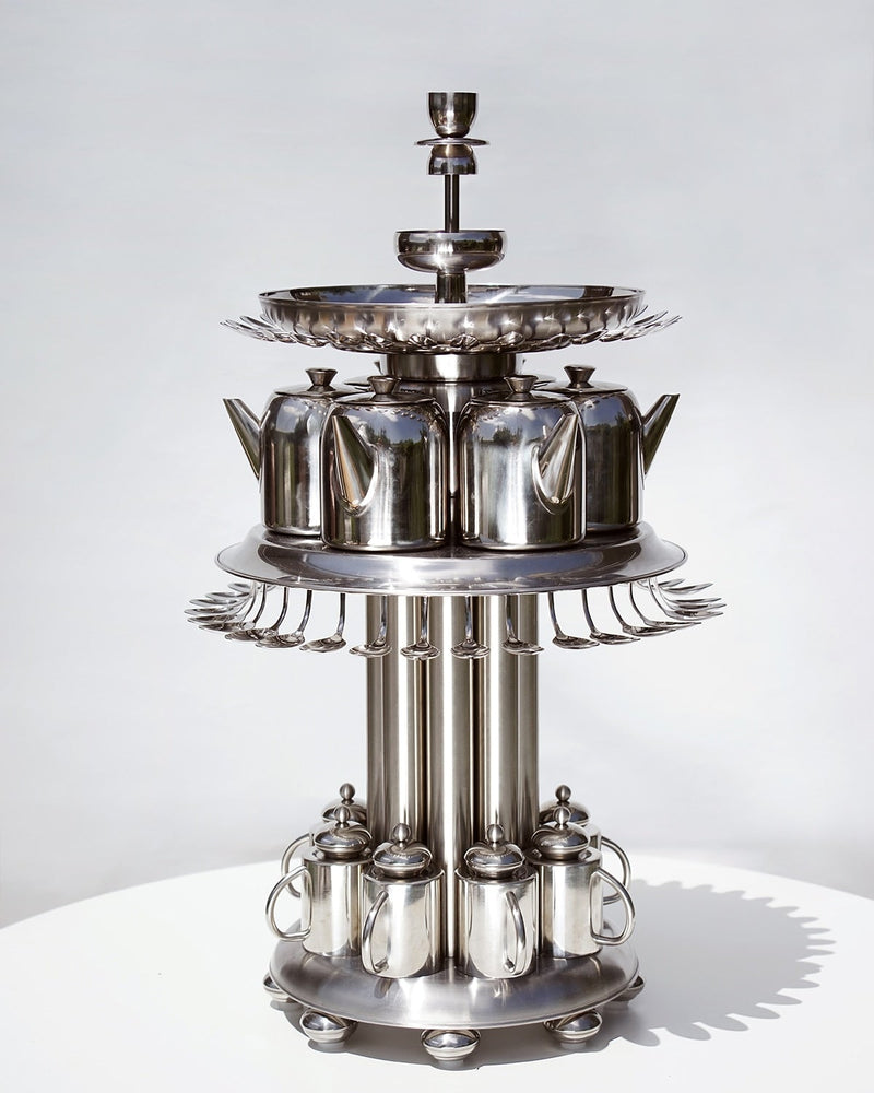 Multi-tier polished steel tea service with teapots and cups