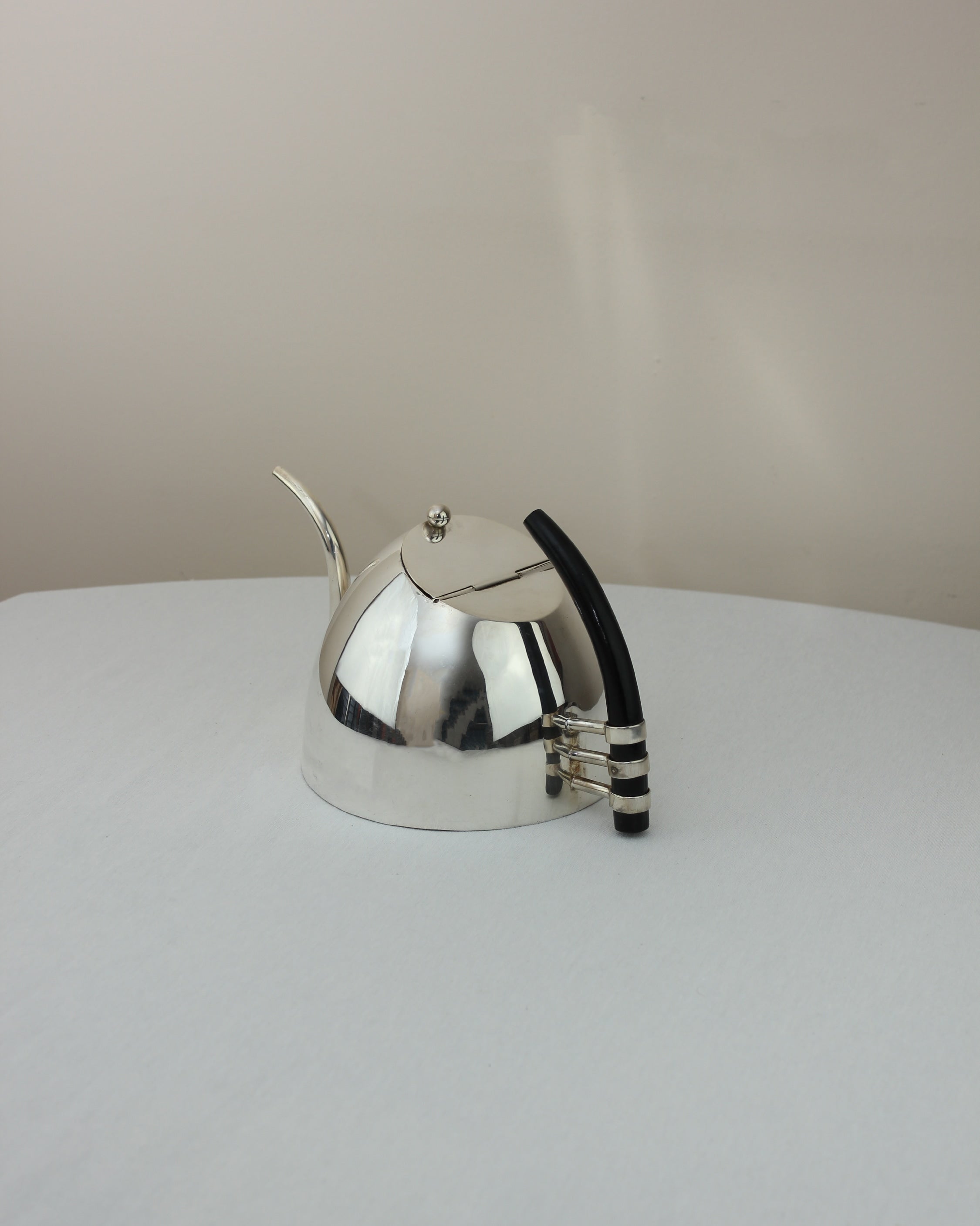 Tetera Italiana — side angle showing polished metal and black handle