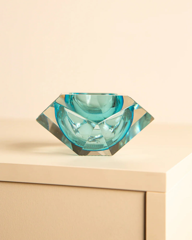 Turquoise Murano glass diamond ashtray on wooden surface