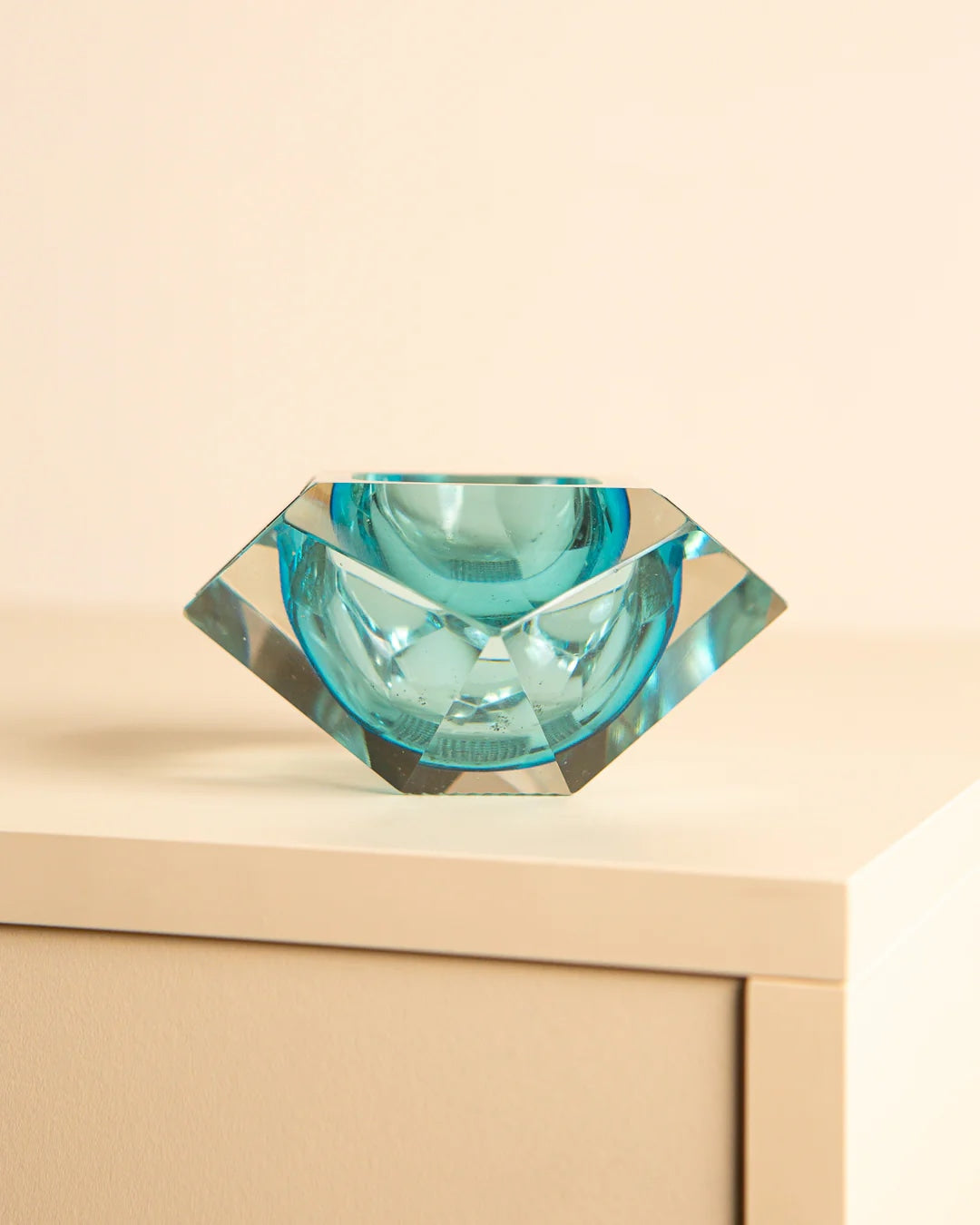 Turquoise Murano glass diamond ashtray on wooden surface