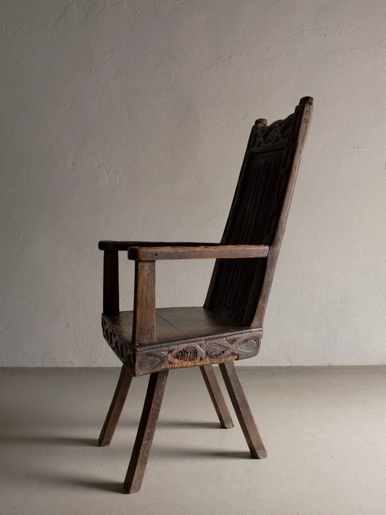 Antique Primitive Carved Oak Arm Chair, Belgium — side profile against neutral wall