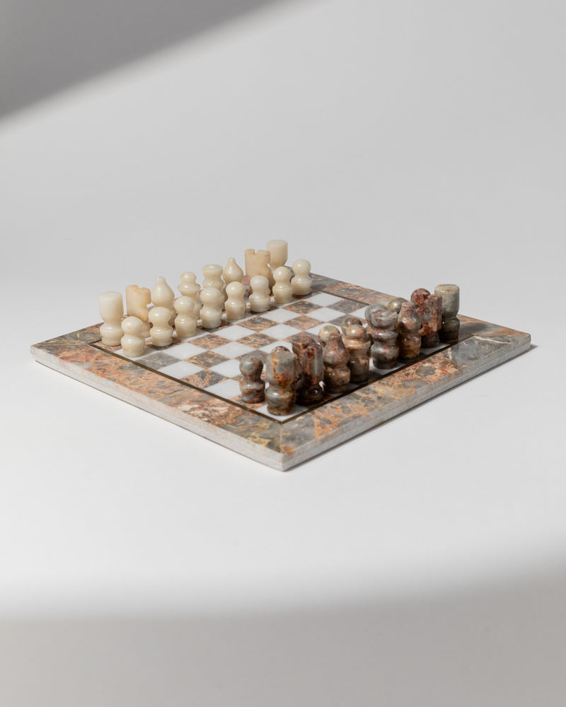 Vintage marble chess set with cream and brown stone pieces on ornate board