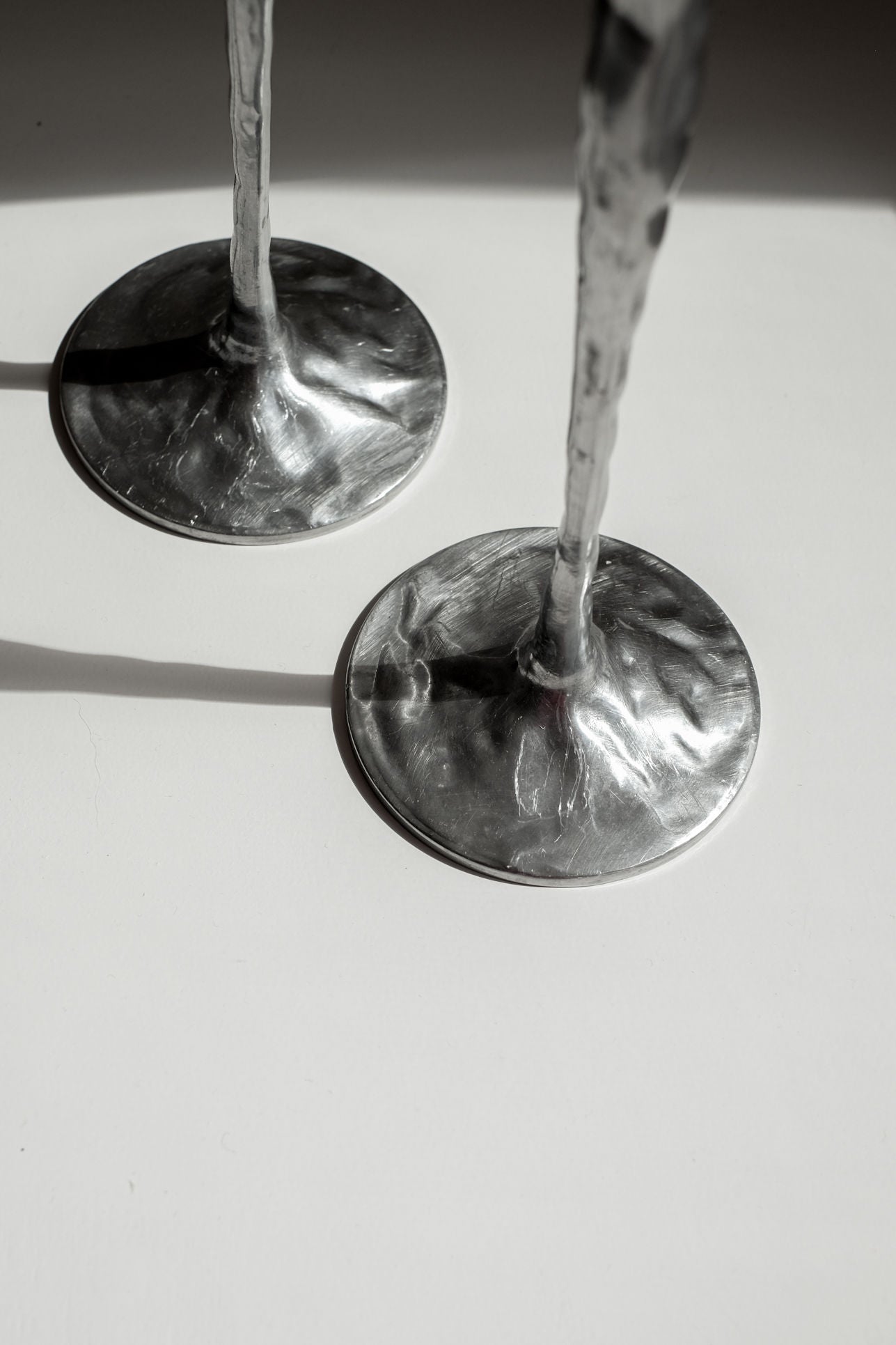 Pair of Aluminium Candle Holders — back view showing textured bases on white surface