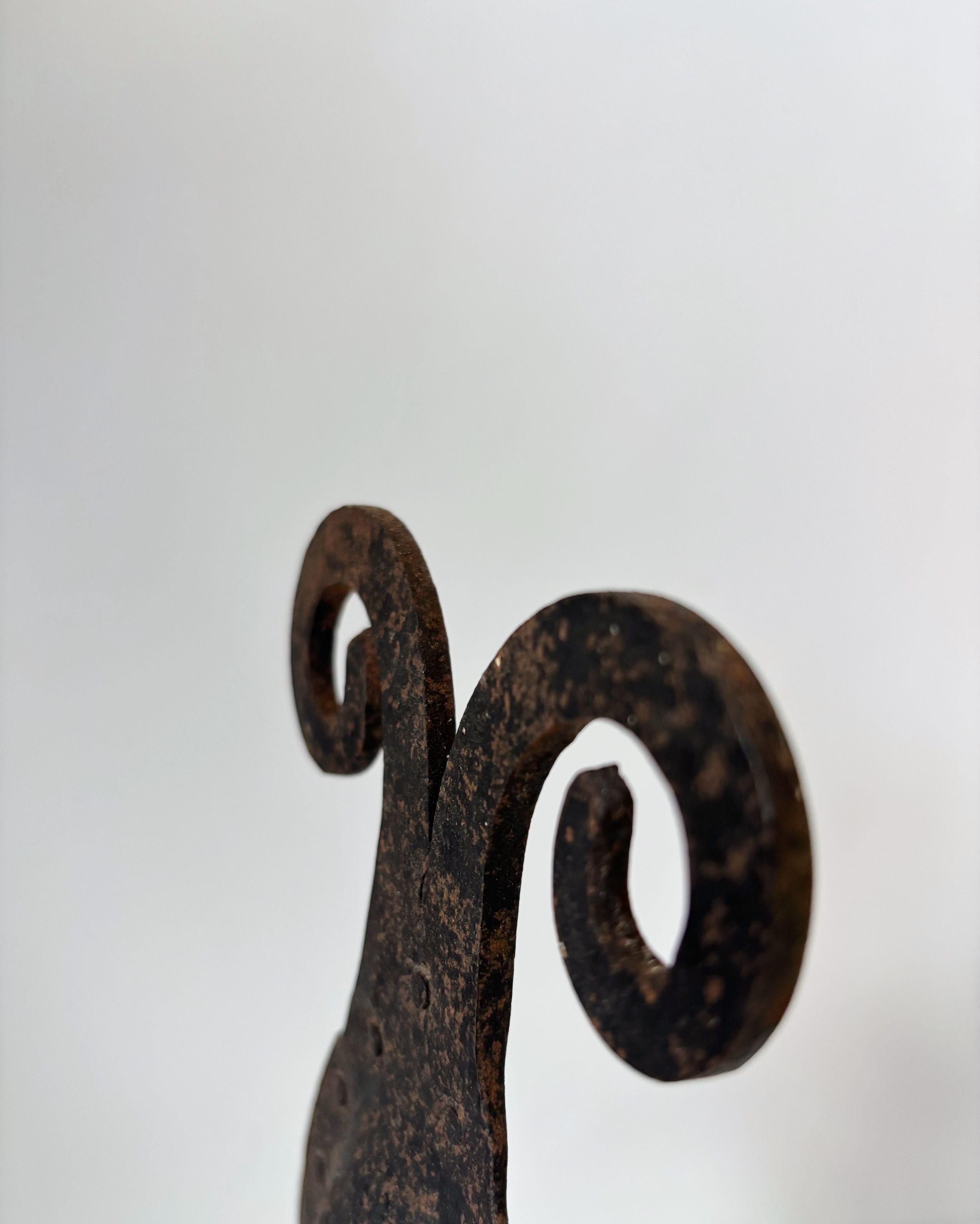 Hand-forged iron candleholder curved spiral detail close-up