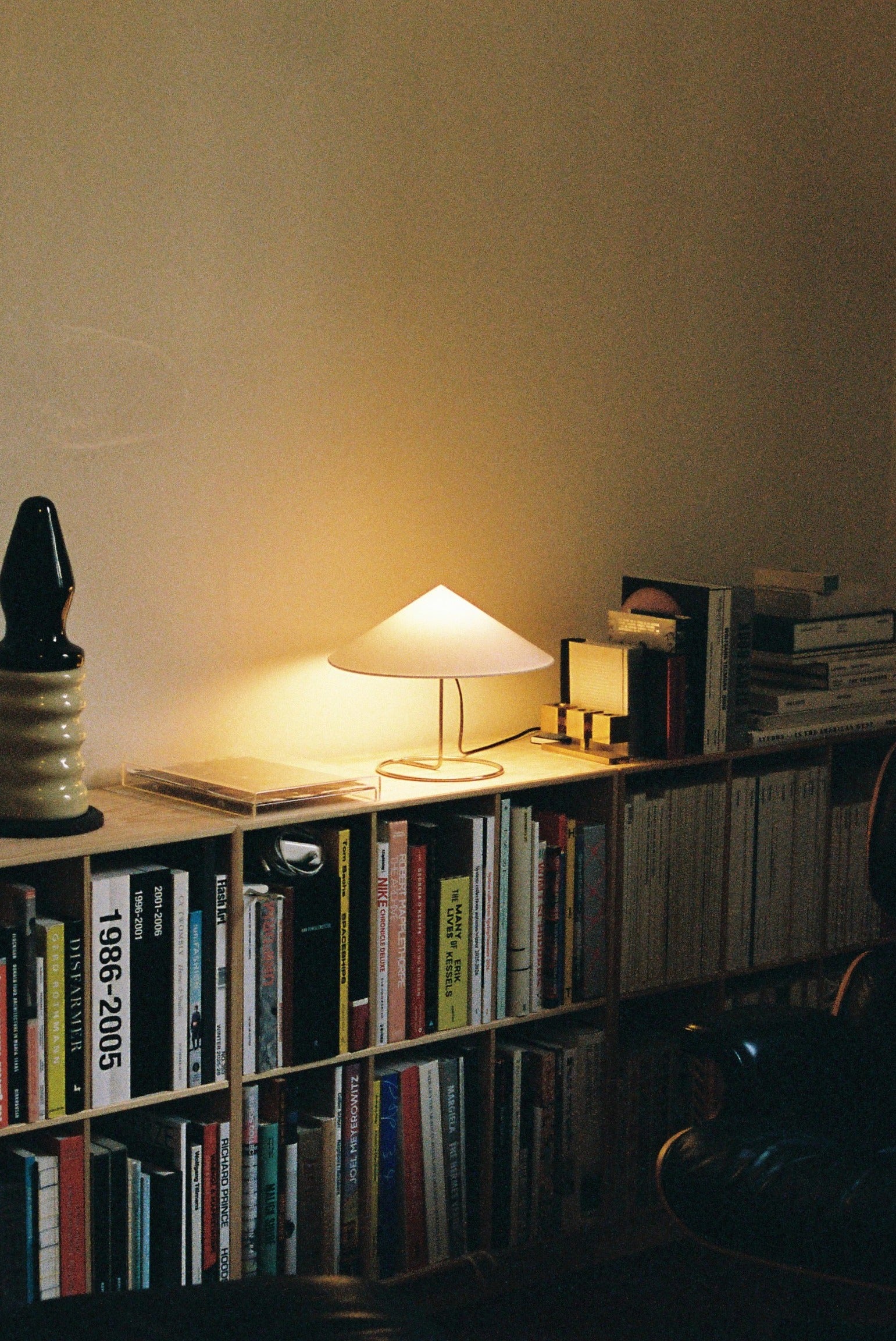 Douli Table Lamp — lit on bookshelf in modern living room
