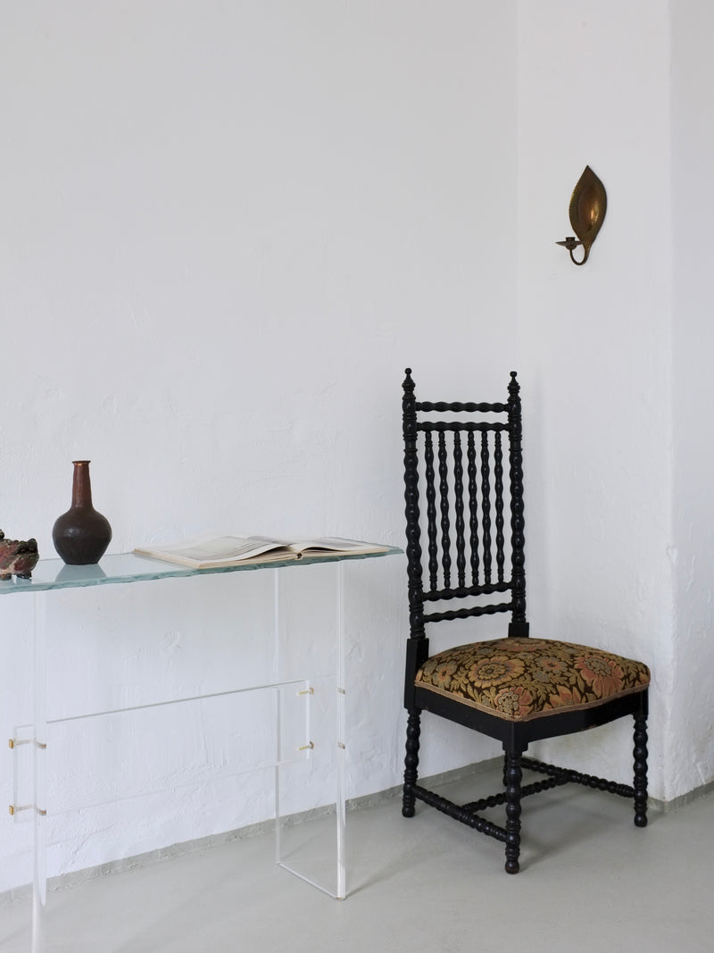Sculptural Lucite console table styled with vintage chair decor