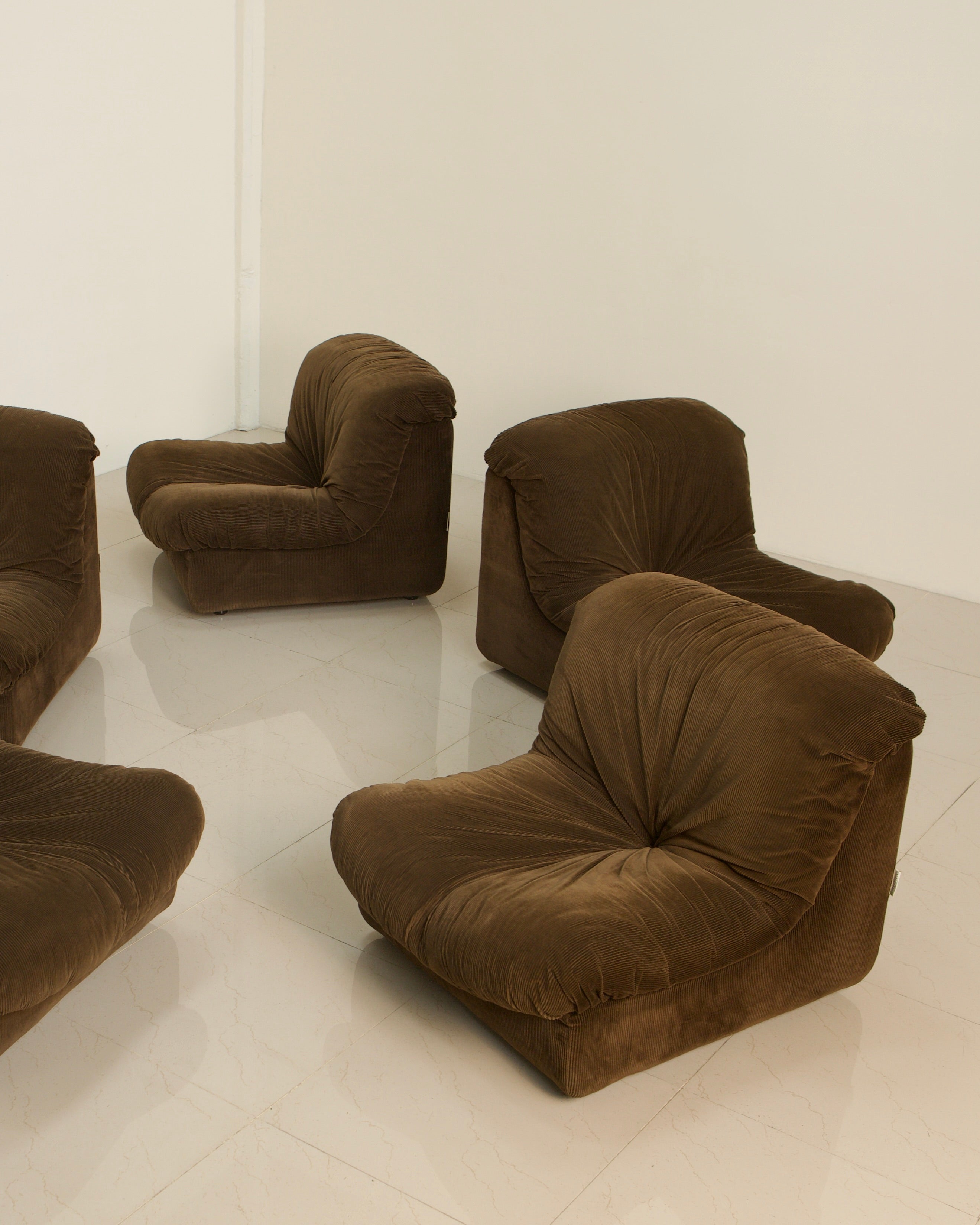 Brown corduroy modular sofa seats arranged on white floor