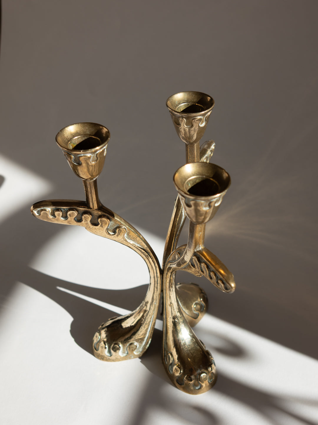Brass Secessionist Three-Arm Candelabra - Austria, c. 1930s — side angle with light reflections on brass