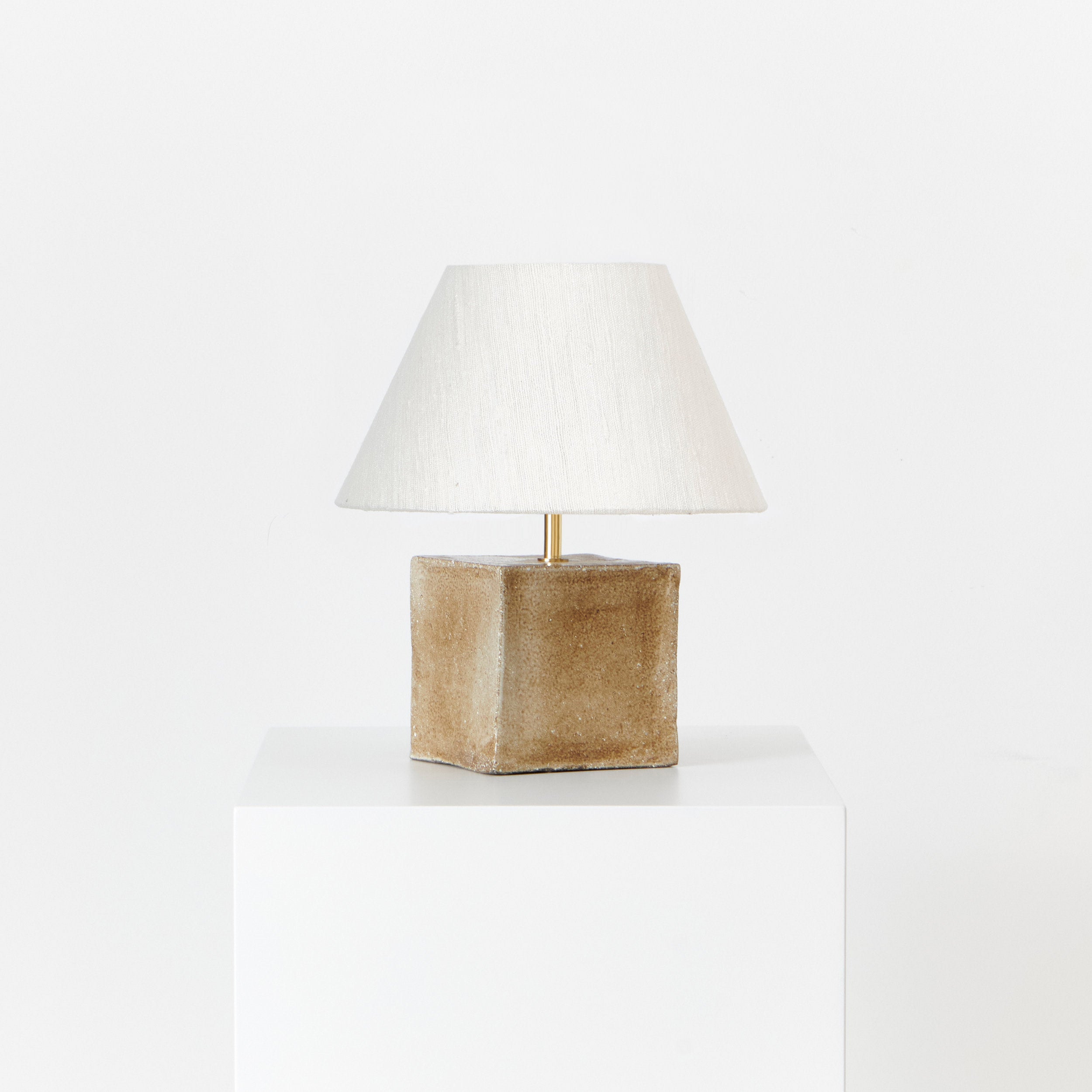 Arouca Table Light Red — back view of textured lamp on white pedestal