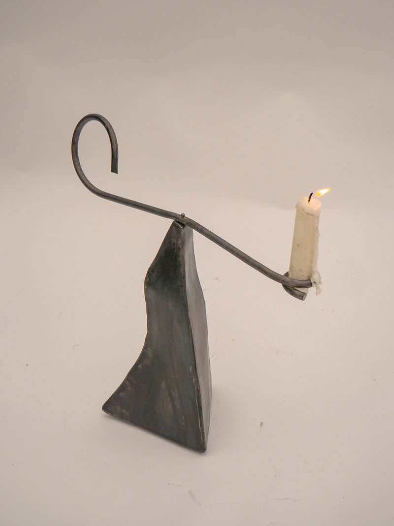 Modern sculptural candle holder with triangular base and curved arm