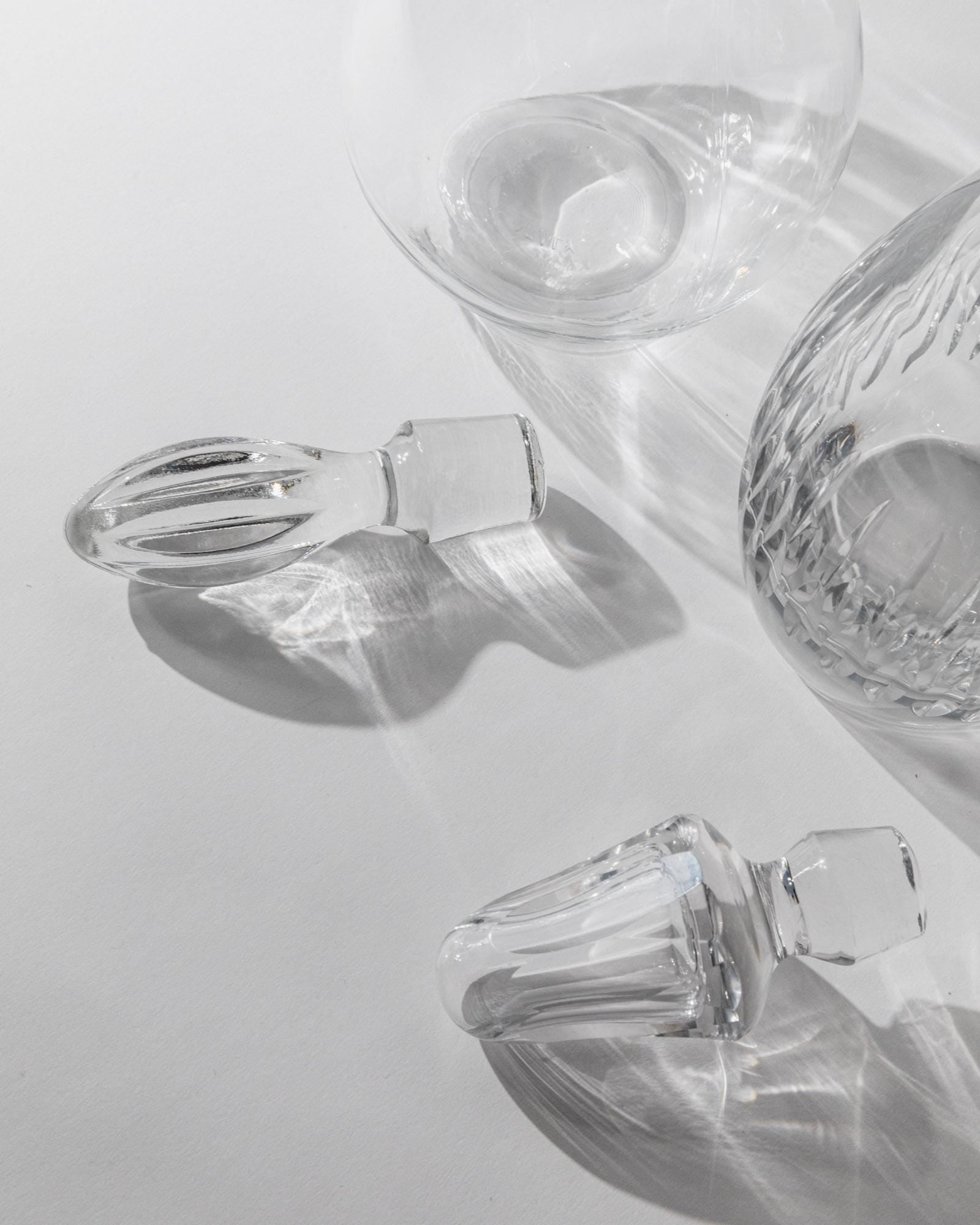 Vintage 1980s Glass Decanter Set of 2 — back view of glass stoppers on white surface