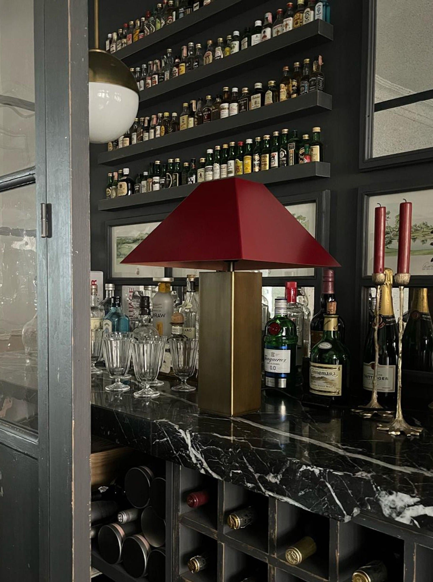 Anni Lamp — positioned on black marble bar with red shade
