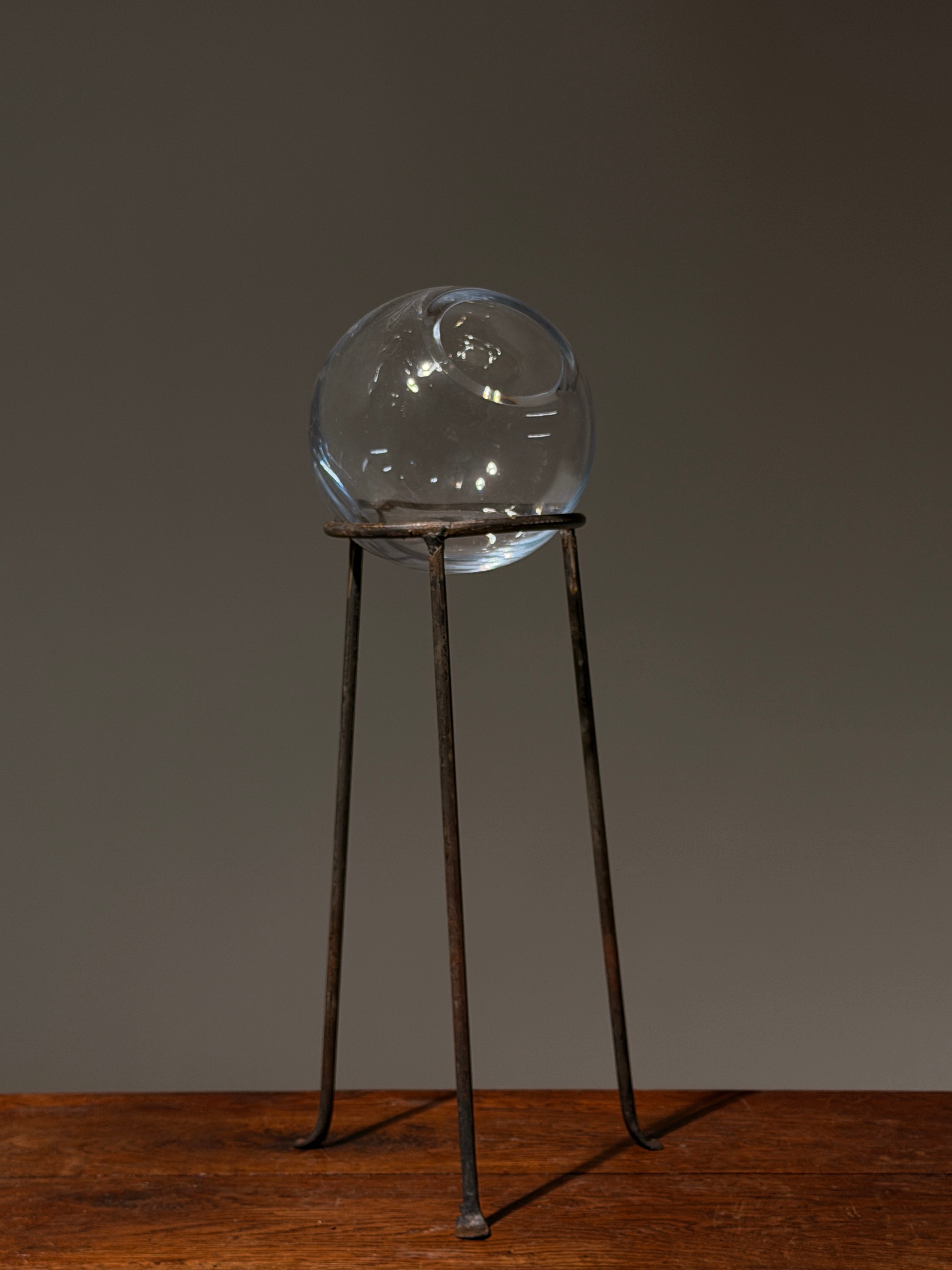 Glass orb vase on wrought iron tripod stand, France, circa 1960 — detail view