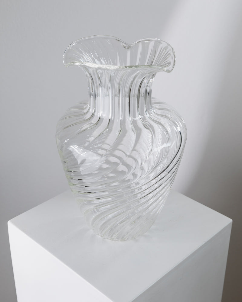 Clear ribbed glass vase with ruffled rim on white pedestal
