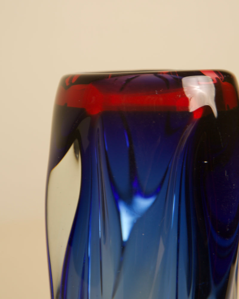 Close-up detail of blue and red Murano glass vase rim
