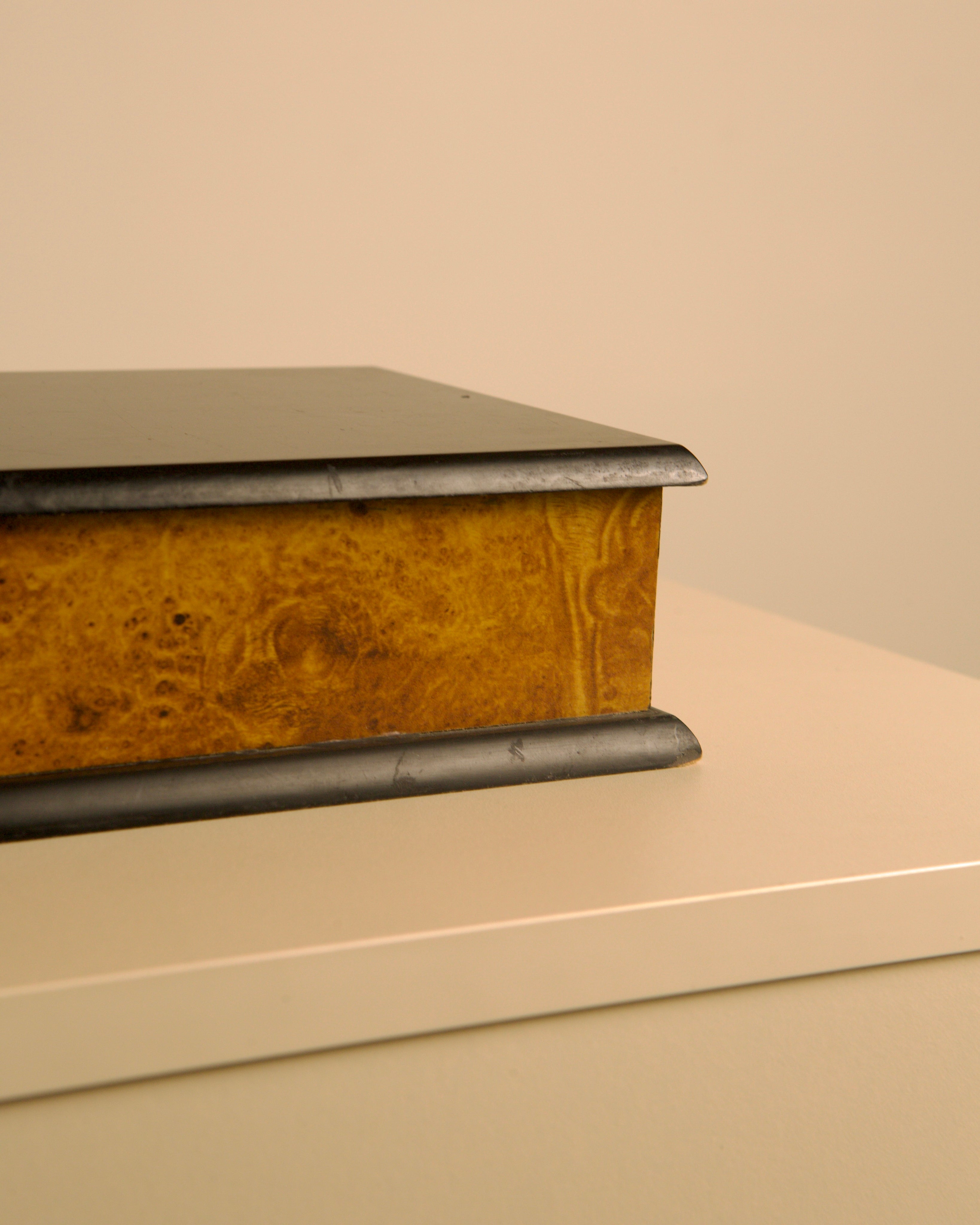 80's Italian rectangular box in black wood and elm burl effect — angled view on light surface
