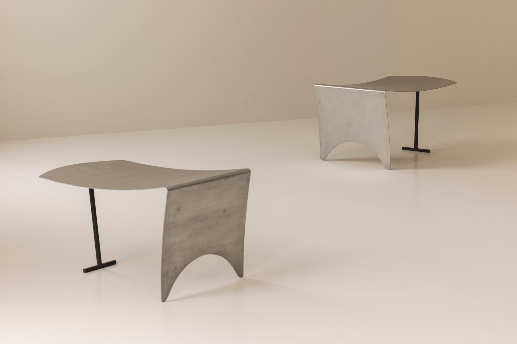 A striking set Modernist curved metal stools from France, dating to the 1980s. — detail view